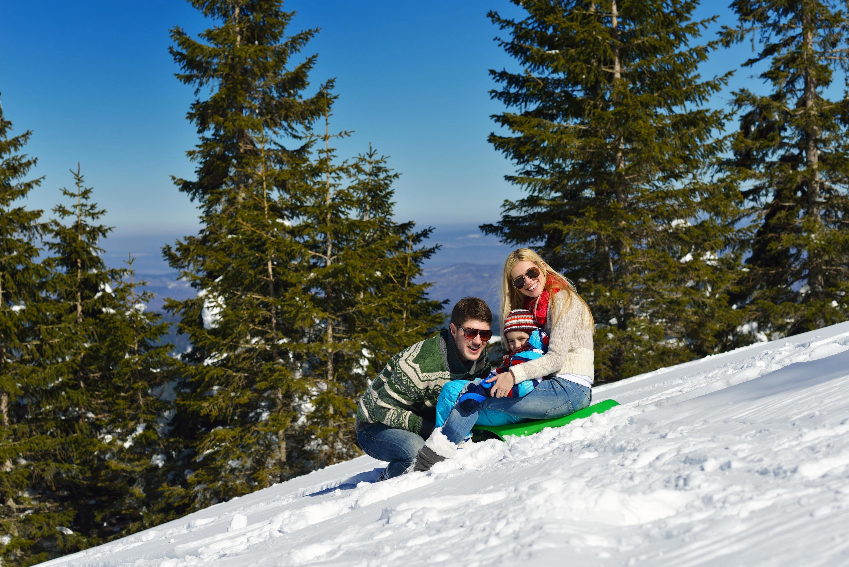 family having fun on fresh snow at winter vacation Stock Free