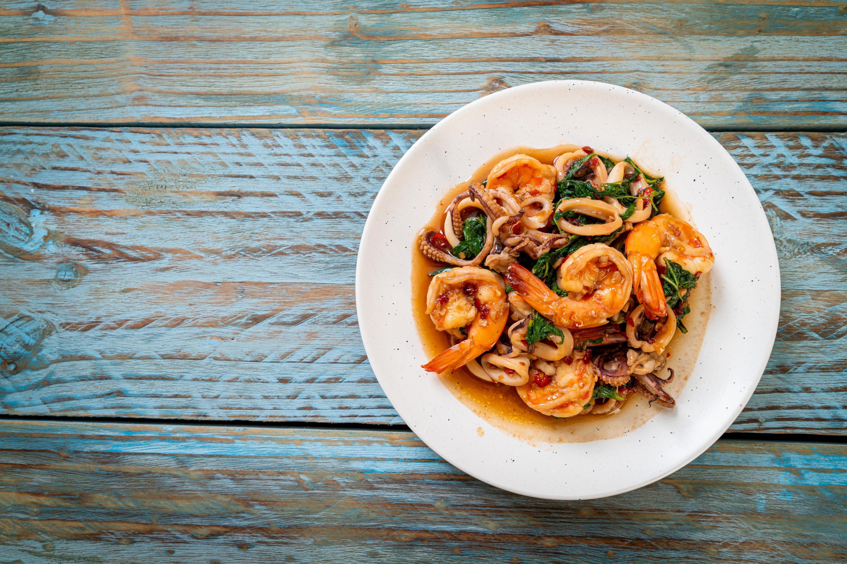 Stir-fried seafood of shrimps and squid with Thai basil – Asian food style Stock Free