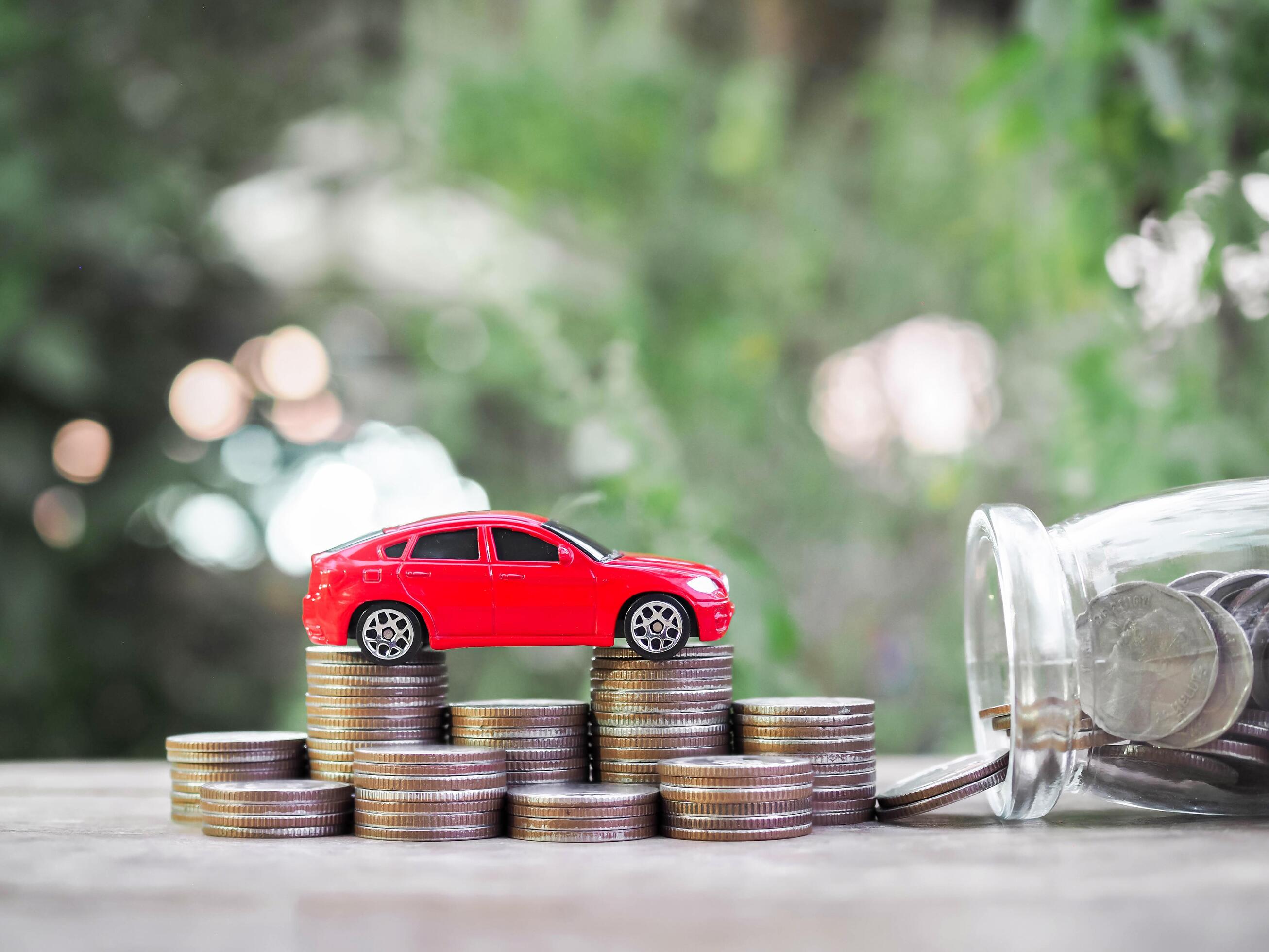 Toy cars on stack of coins. The concept of saving money and manage to success transport business Stock Free