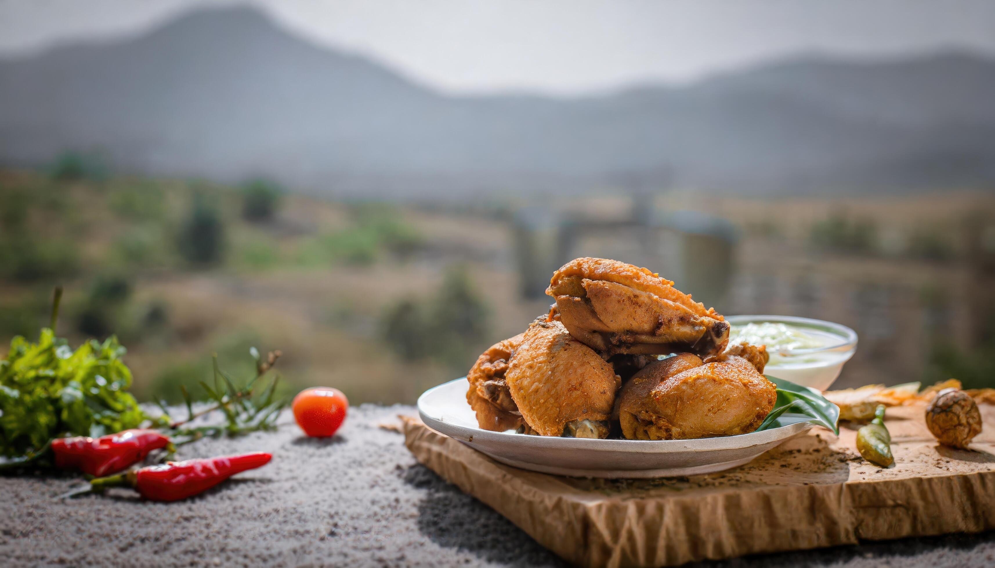 Copy Space image of Fried and Crispy Chicken Gizzards on a Rustic Wooden Table with landscape view background. Stock Free