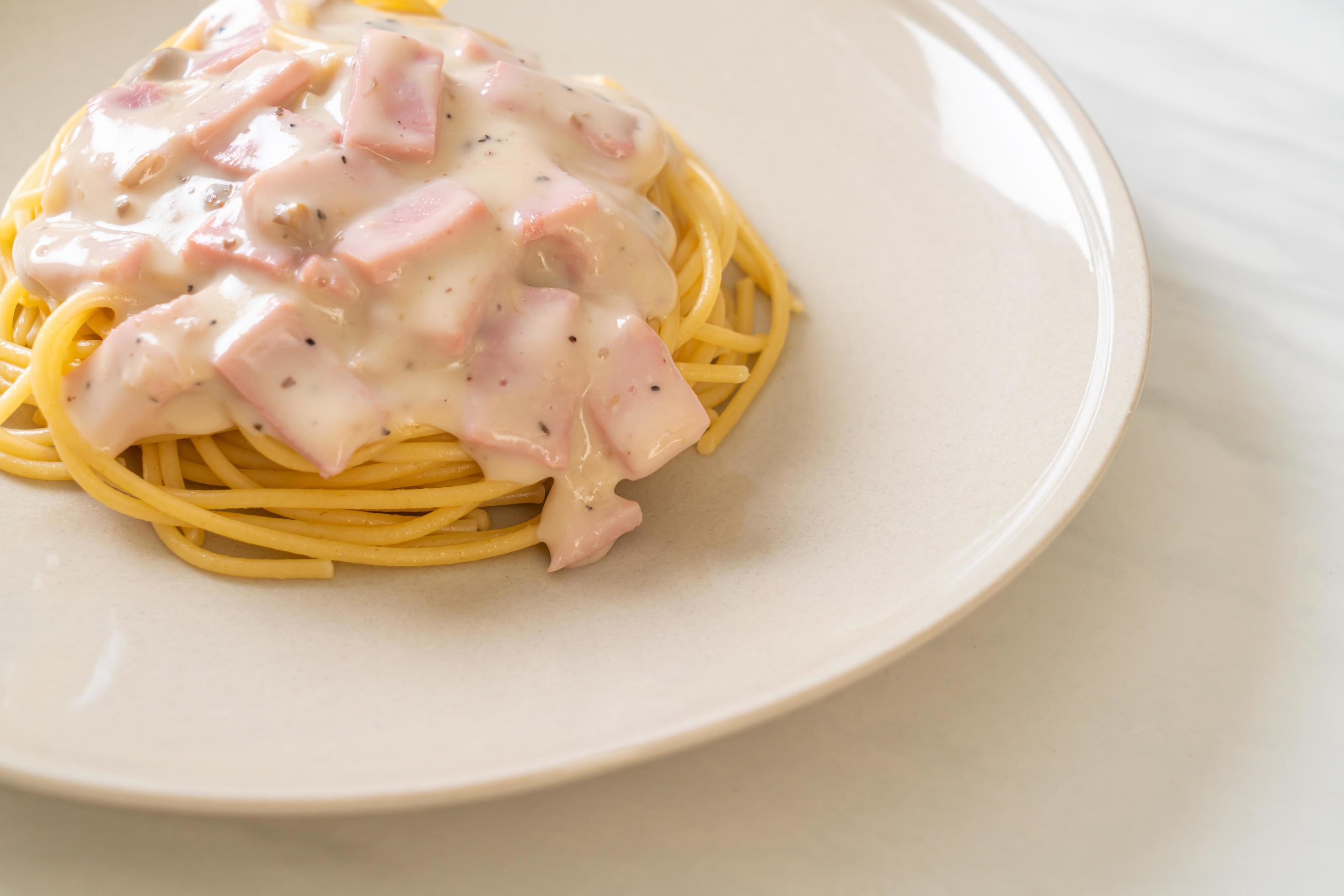 Homemade spaghetti white cream sauce with ham – Italian food style Stock Free