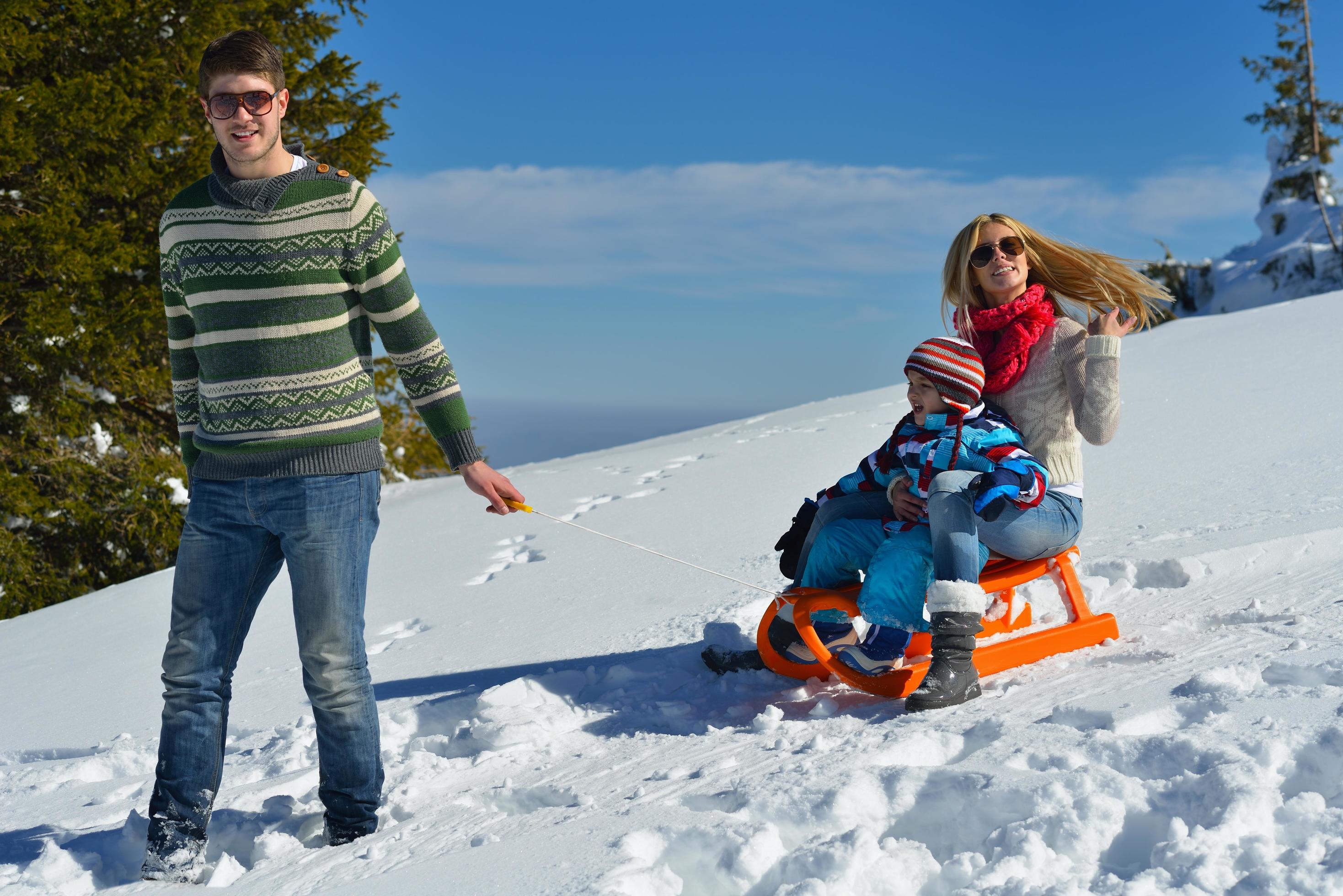 family having fun on fresh snow at winter vacation Stock Free