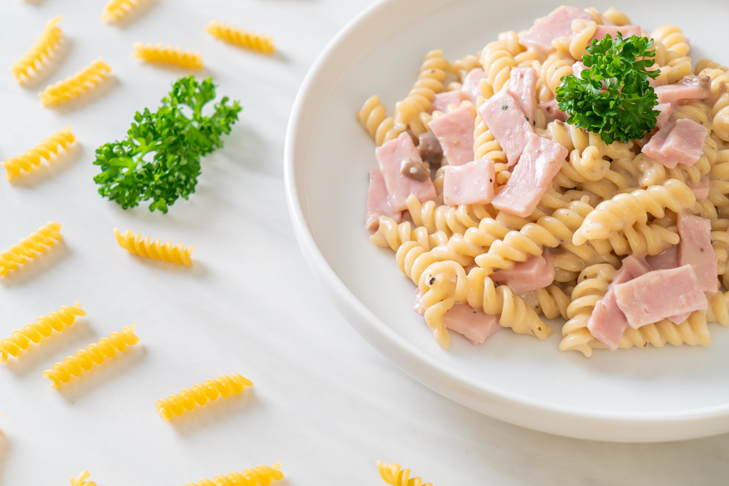 Spirali or spiral pasta mushroom cream sauce with ham – Italian food style Stock Free