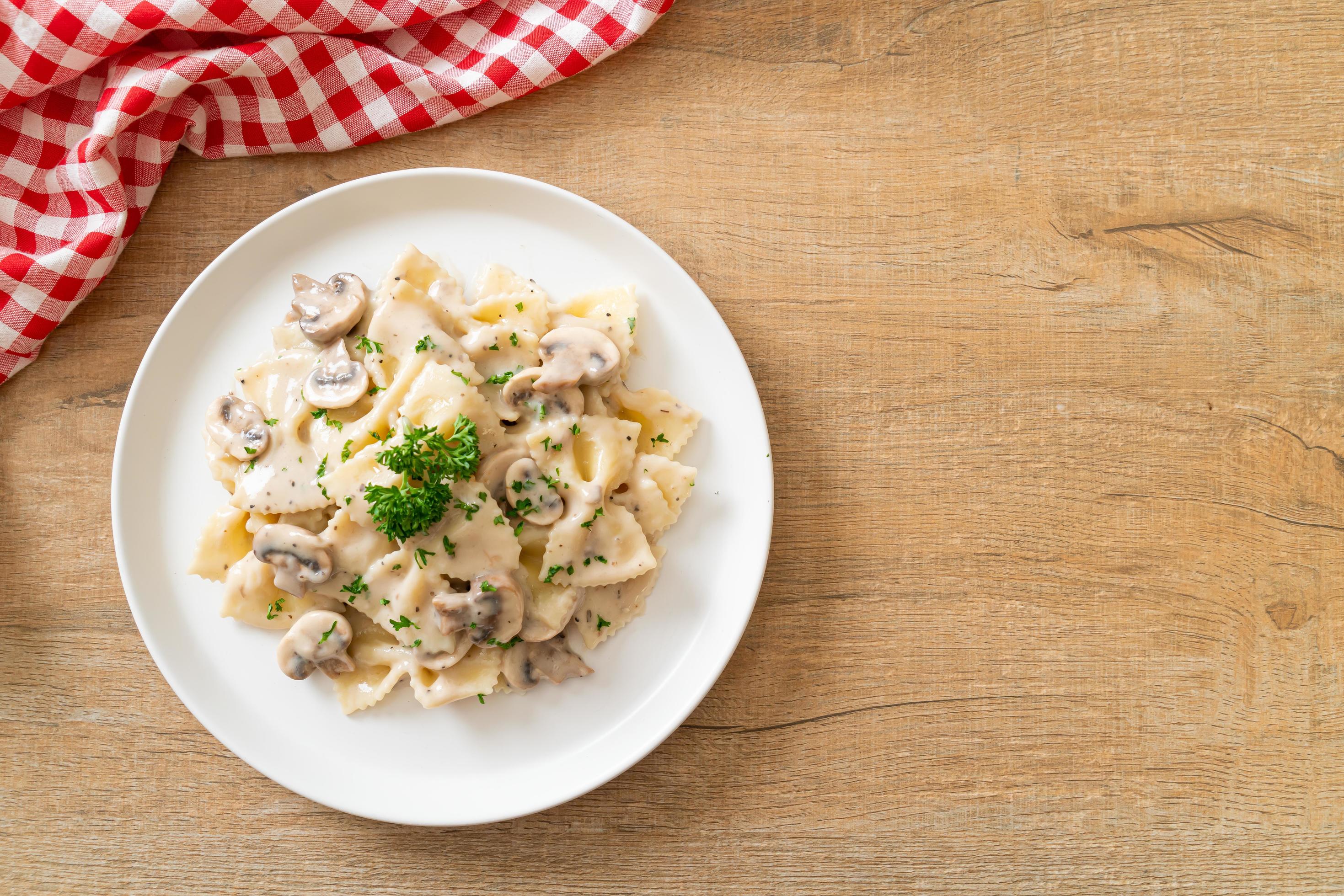 Farfalle pasta with mushroom white cream sauce – Italian food style Stock Free