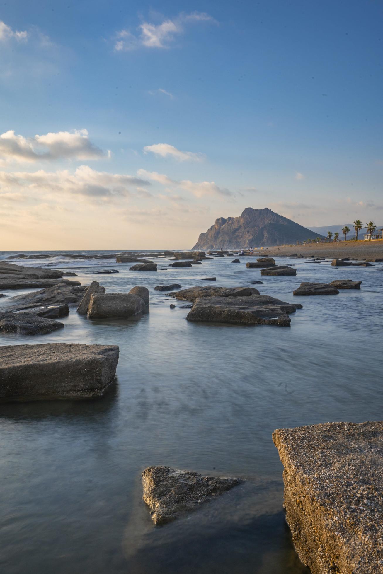 Long exposure photography of waves and pebbles on Beach in the sunset Stock Free