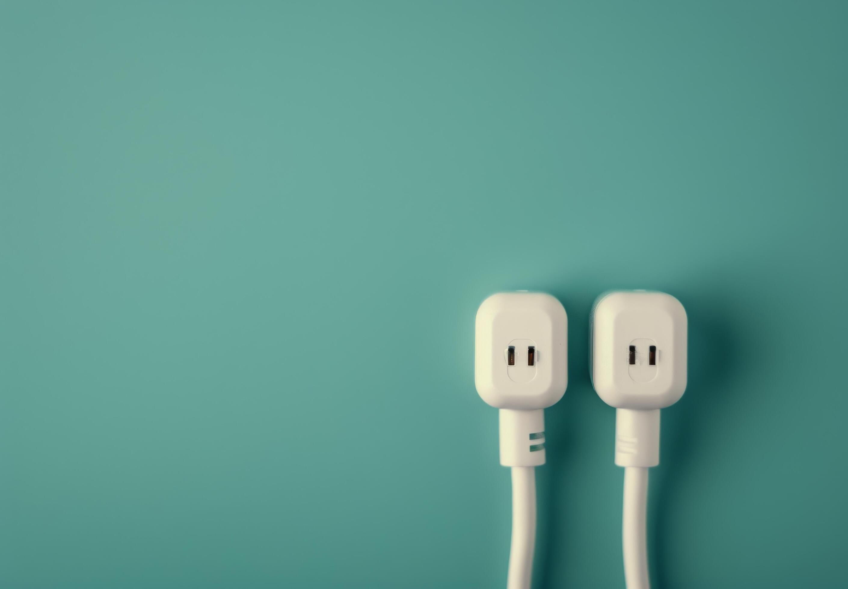 Two White Electrical Plugs on Teal Background Stock Free