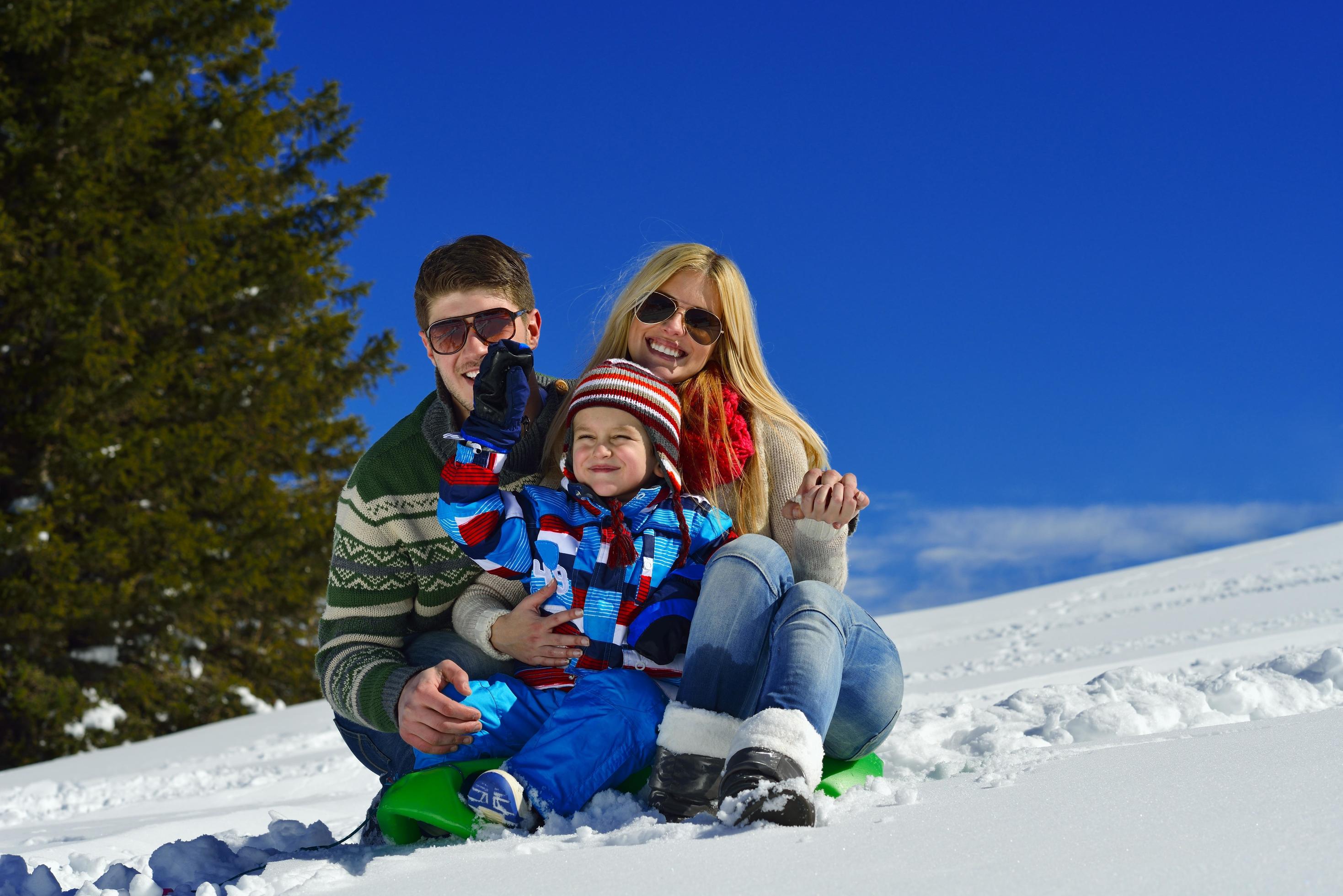 family having fun on fresh snow at winter vacation Stock Free