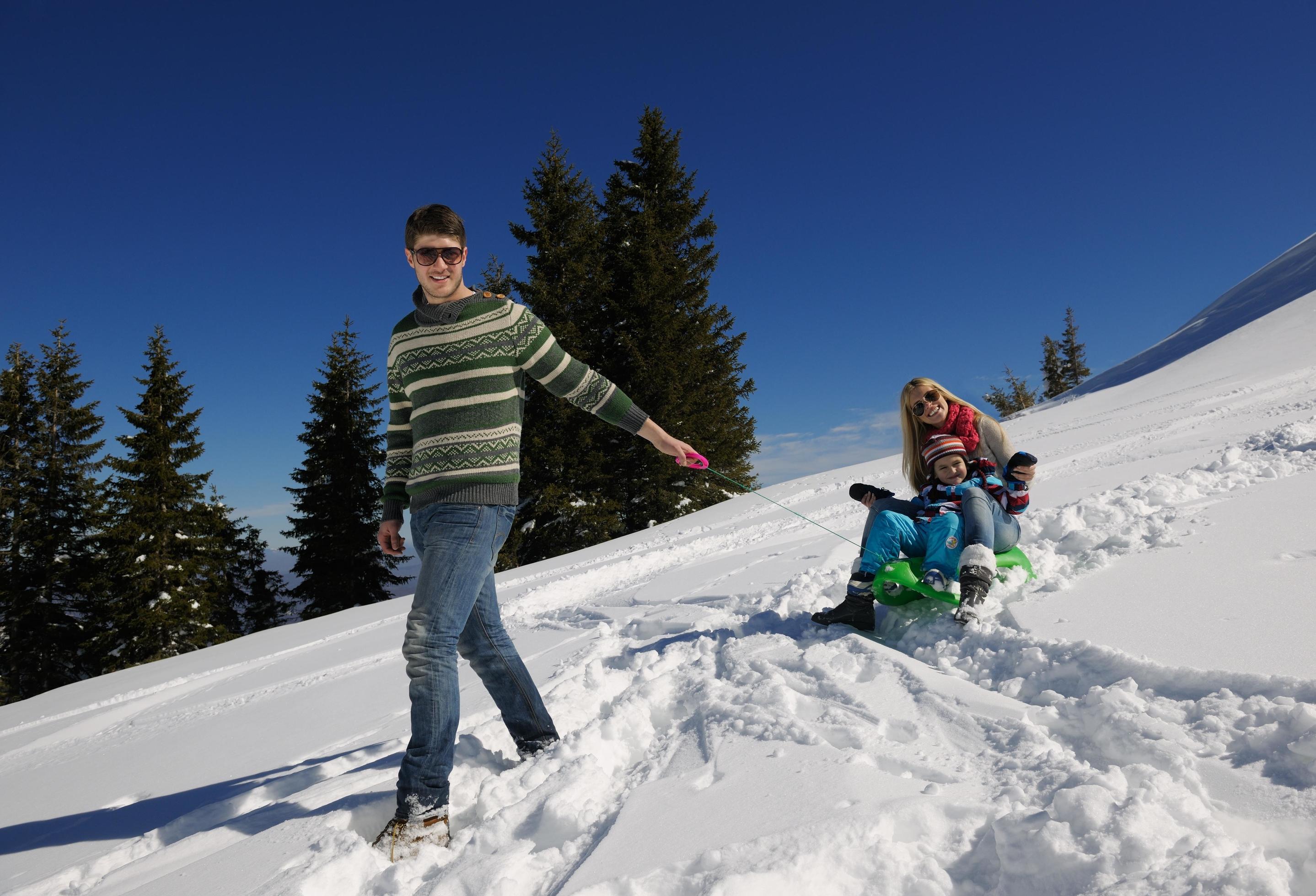 family having fun on fresh snow at winter vacation Stock Free