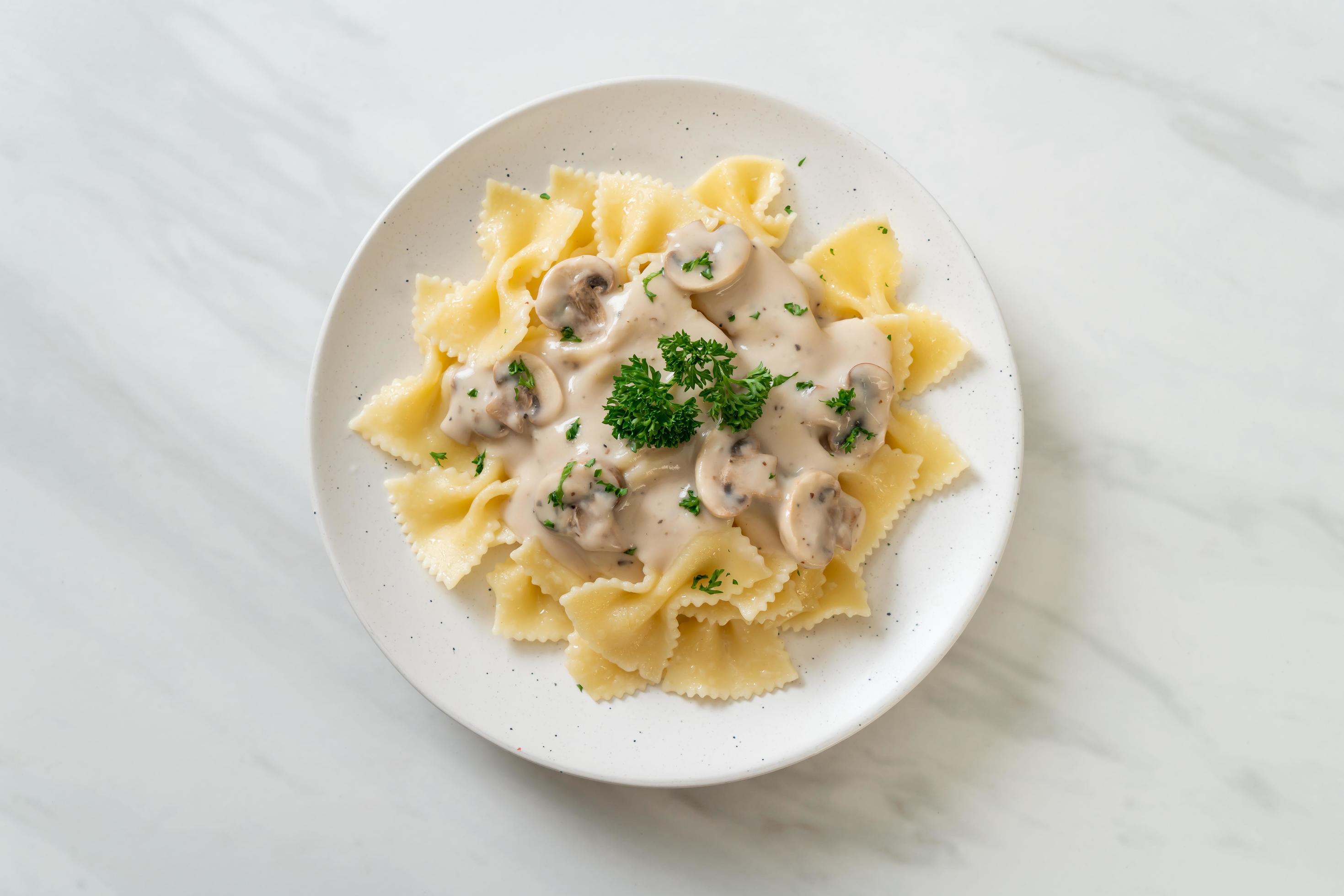 Farfalle pasta with mushroom white cream sauce – Italian food style Stock Free