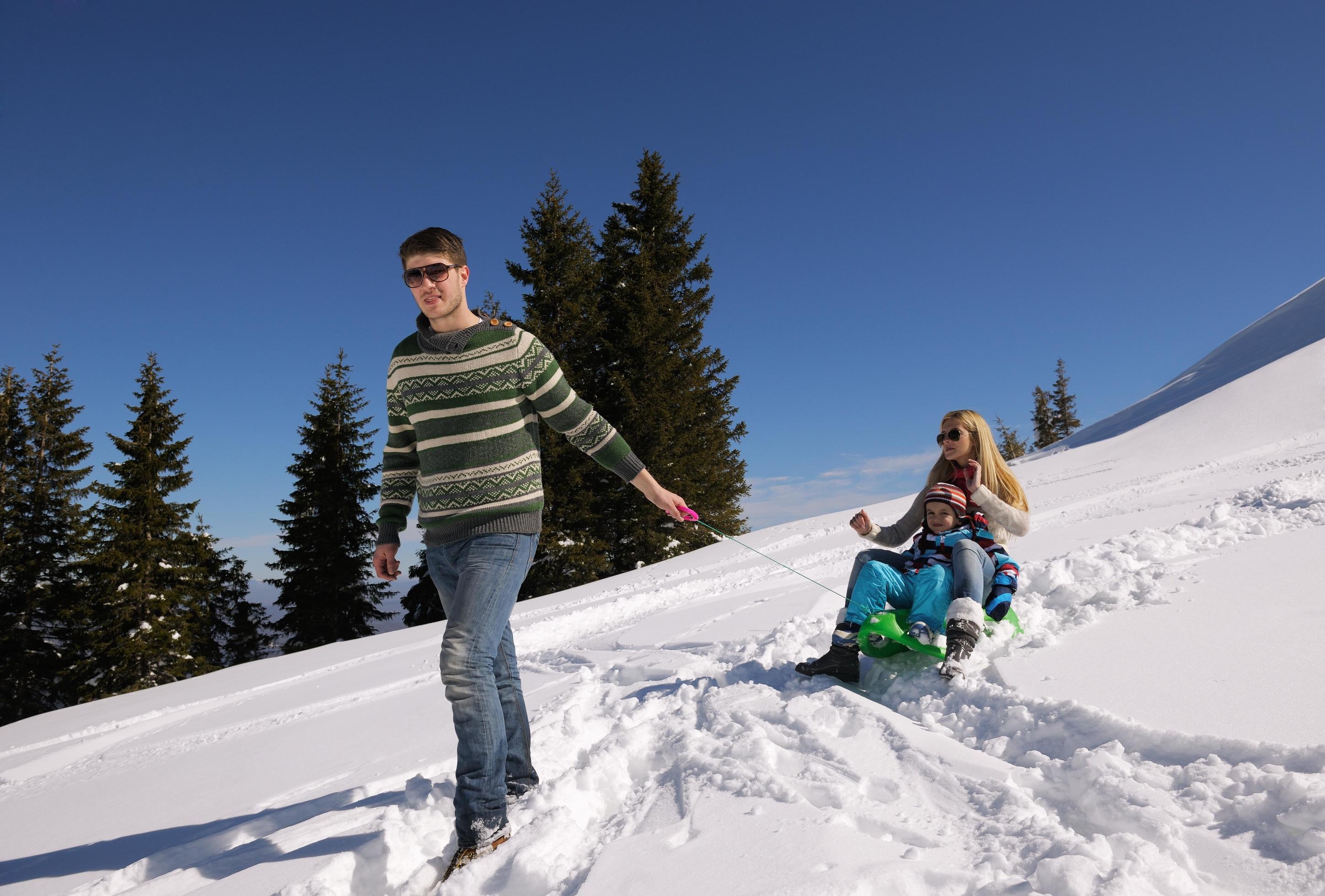 family having fun on fresh snow at winter vacation Stock Free