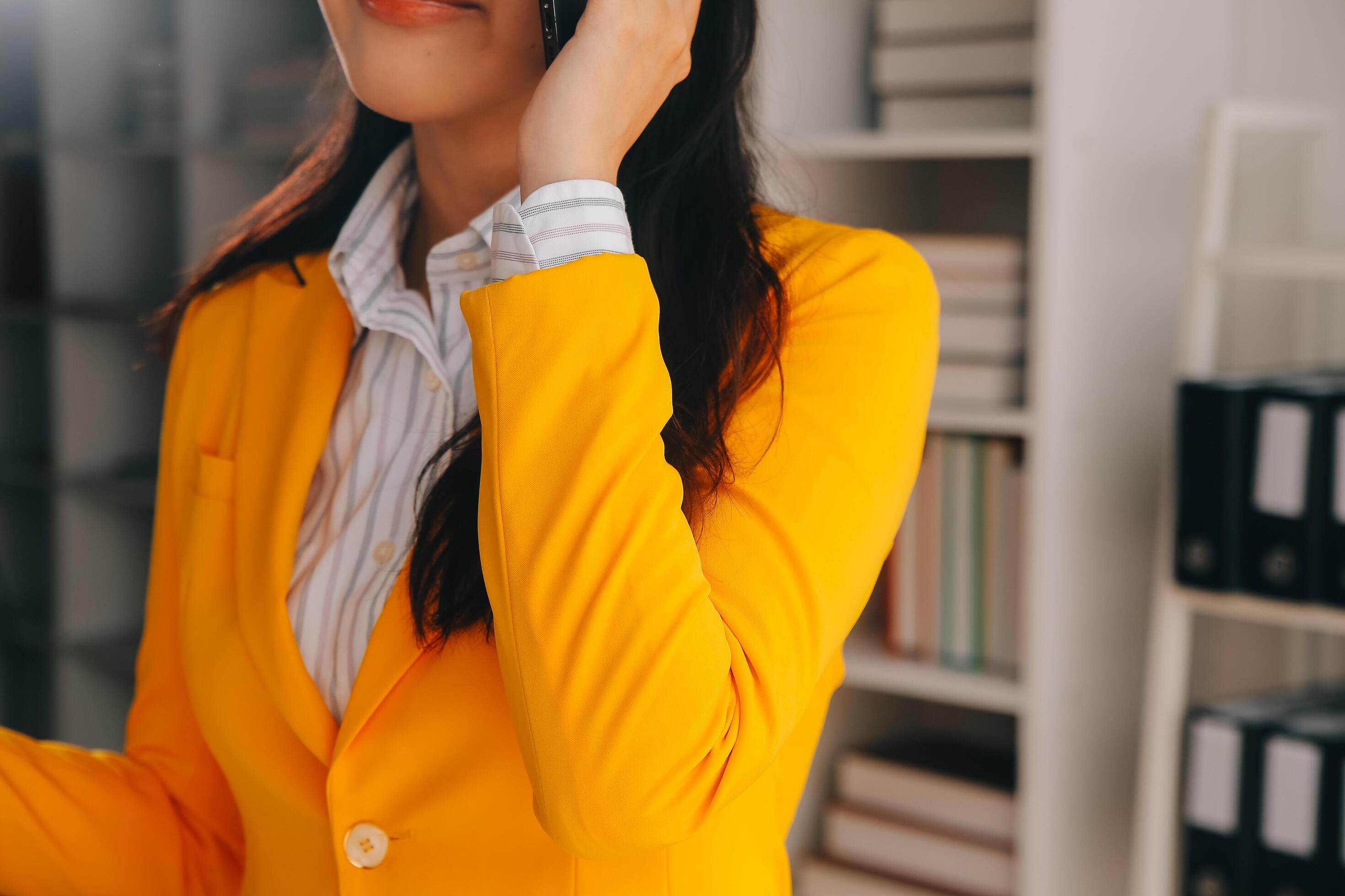 Young smiling business woman using smartphone near computer in office, copy space Stock Free