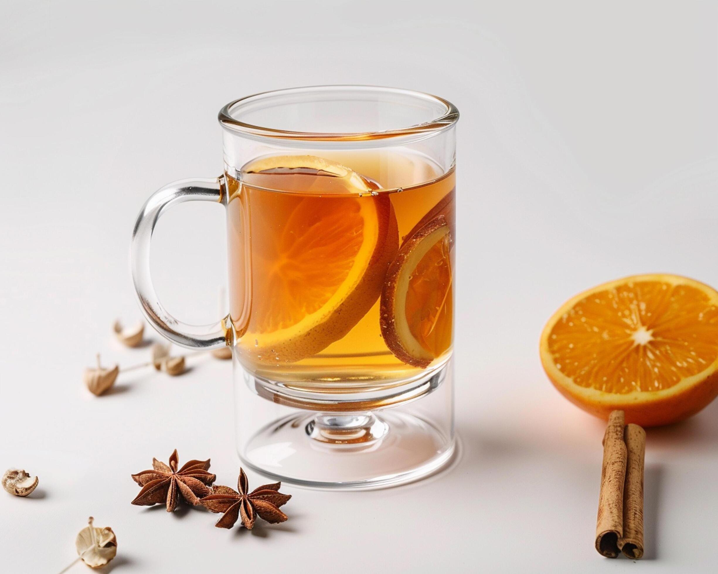 a glass of hot tea with an orange slice and cinnamon Stock Free