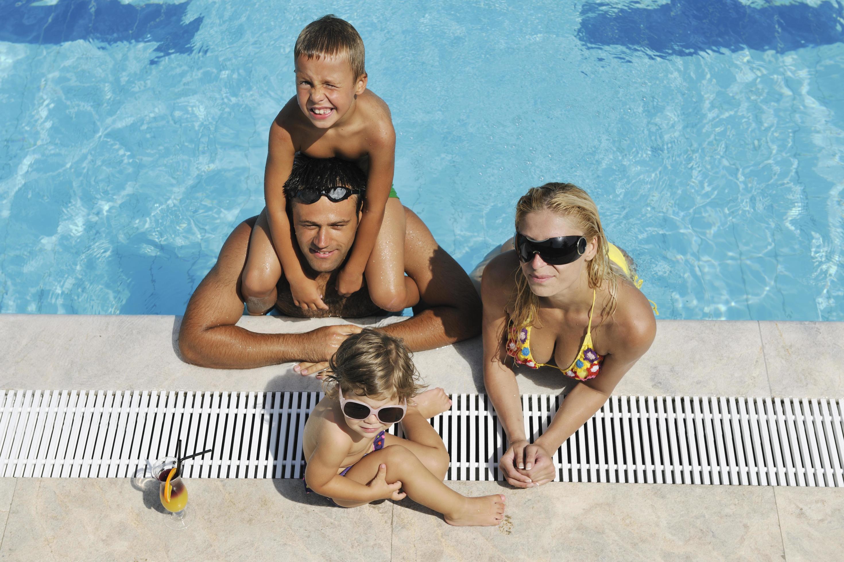 happy young family have fun on swimming pool Stock Free