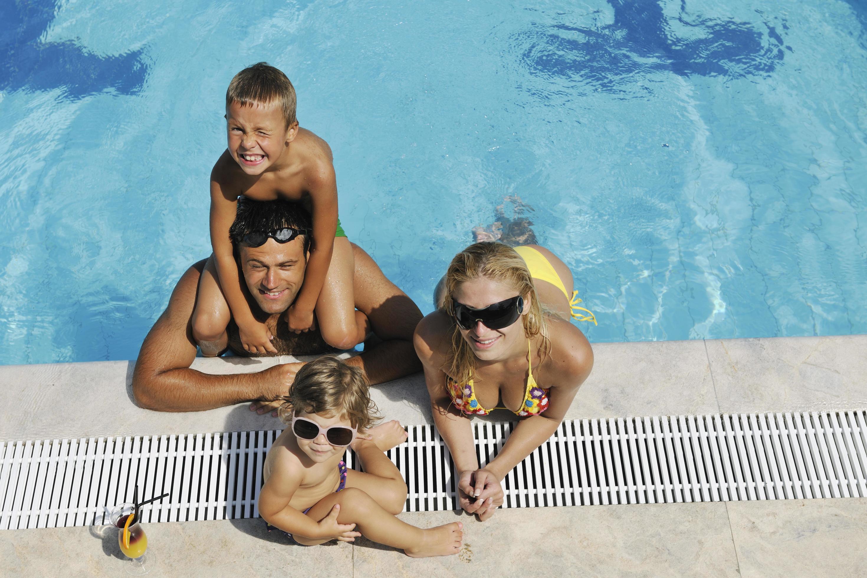 happy young family have fun on swimming pool Stock Free