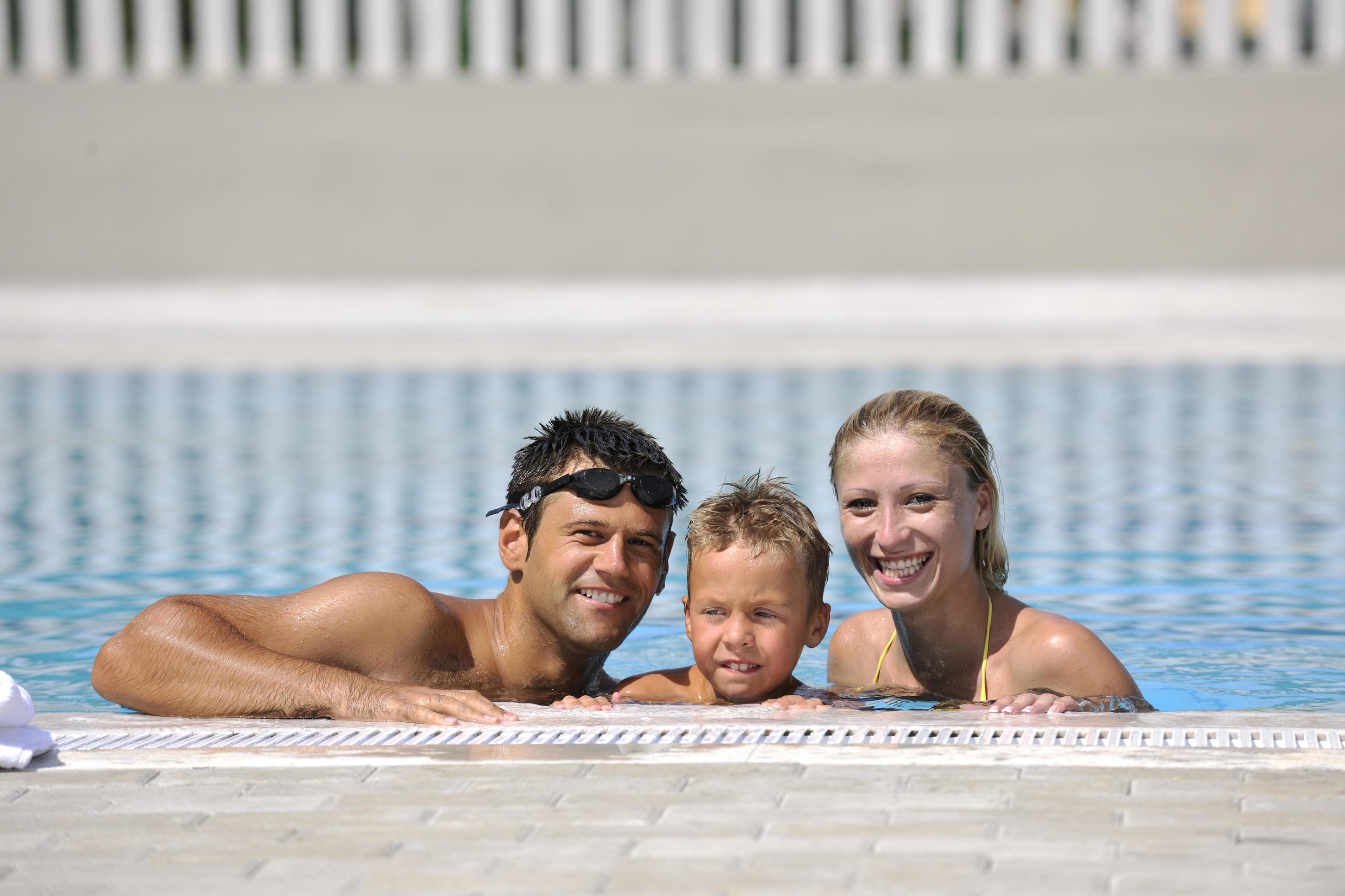 happy young family have fun on swimming pool Stock Free