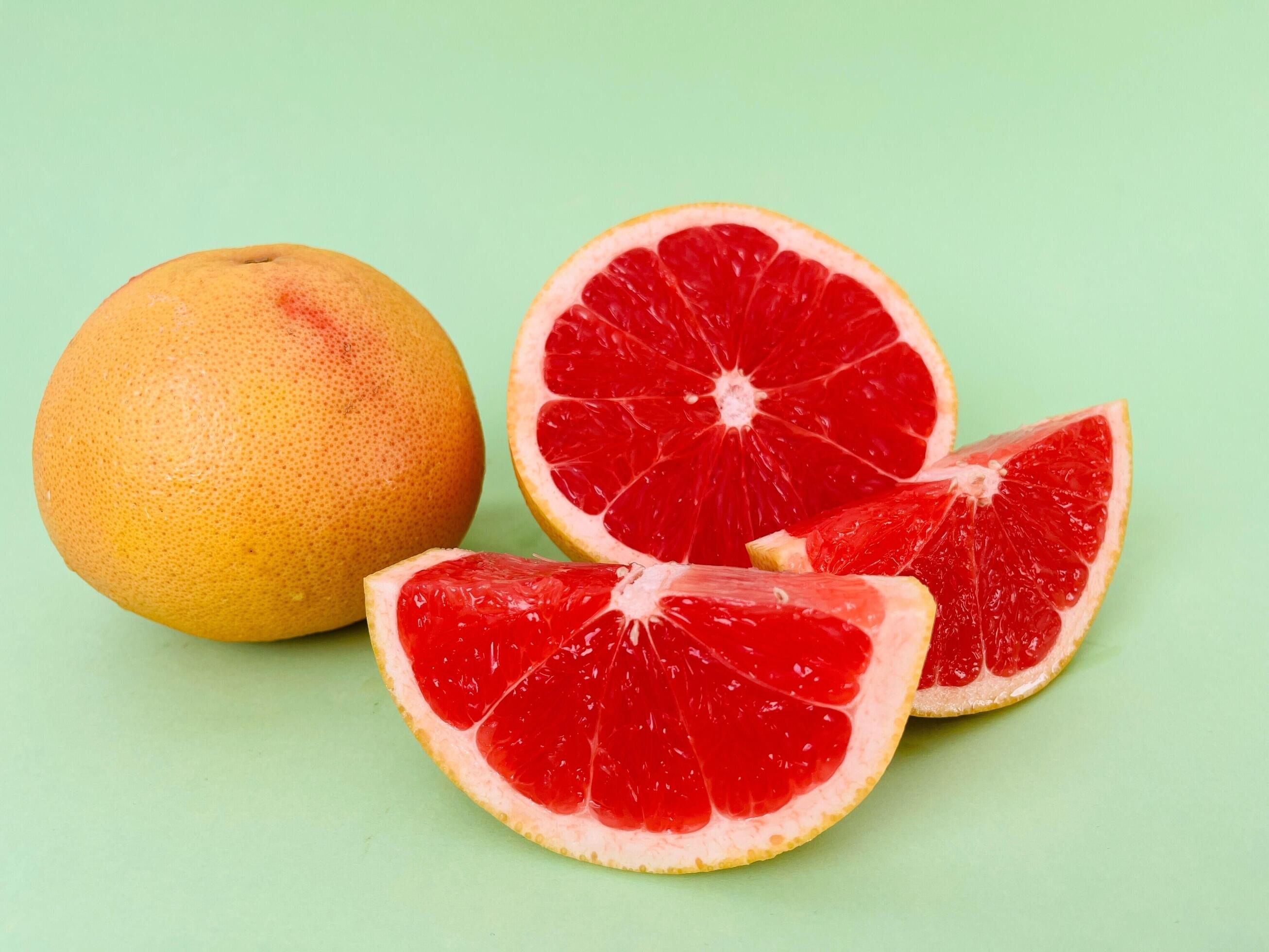 Fresh grapefruit fruit. Grapefruit isolated on green background. Grapefruit with clipping path. Stock Free