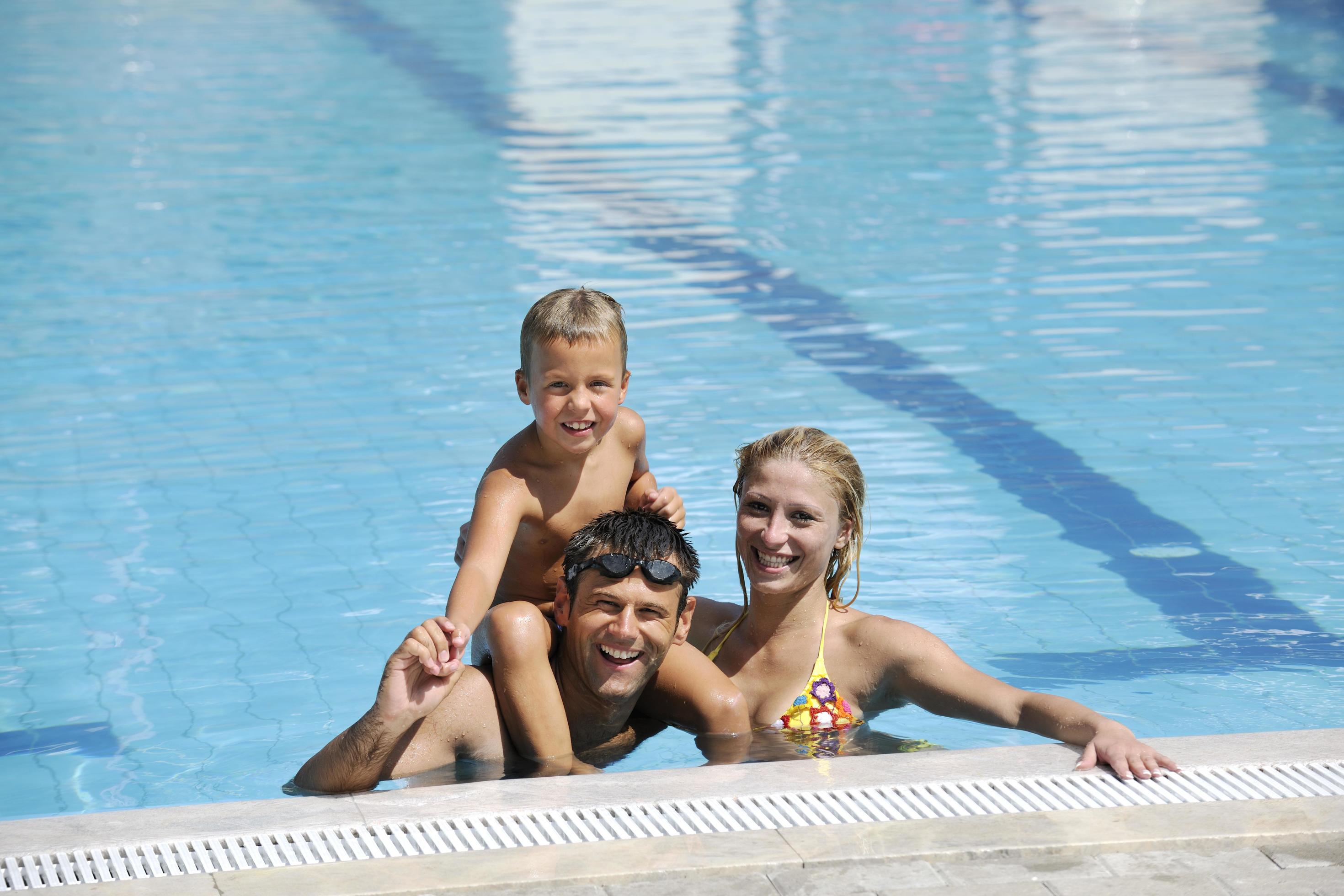 happy young family have fun on swimming pool Stock Free