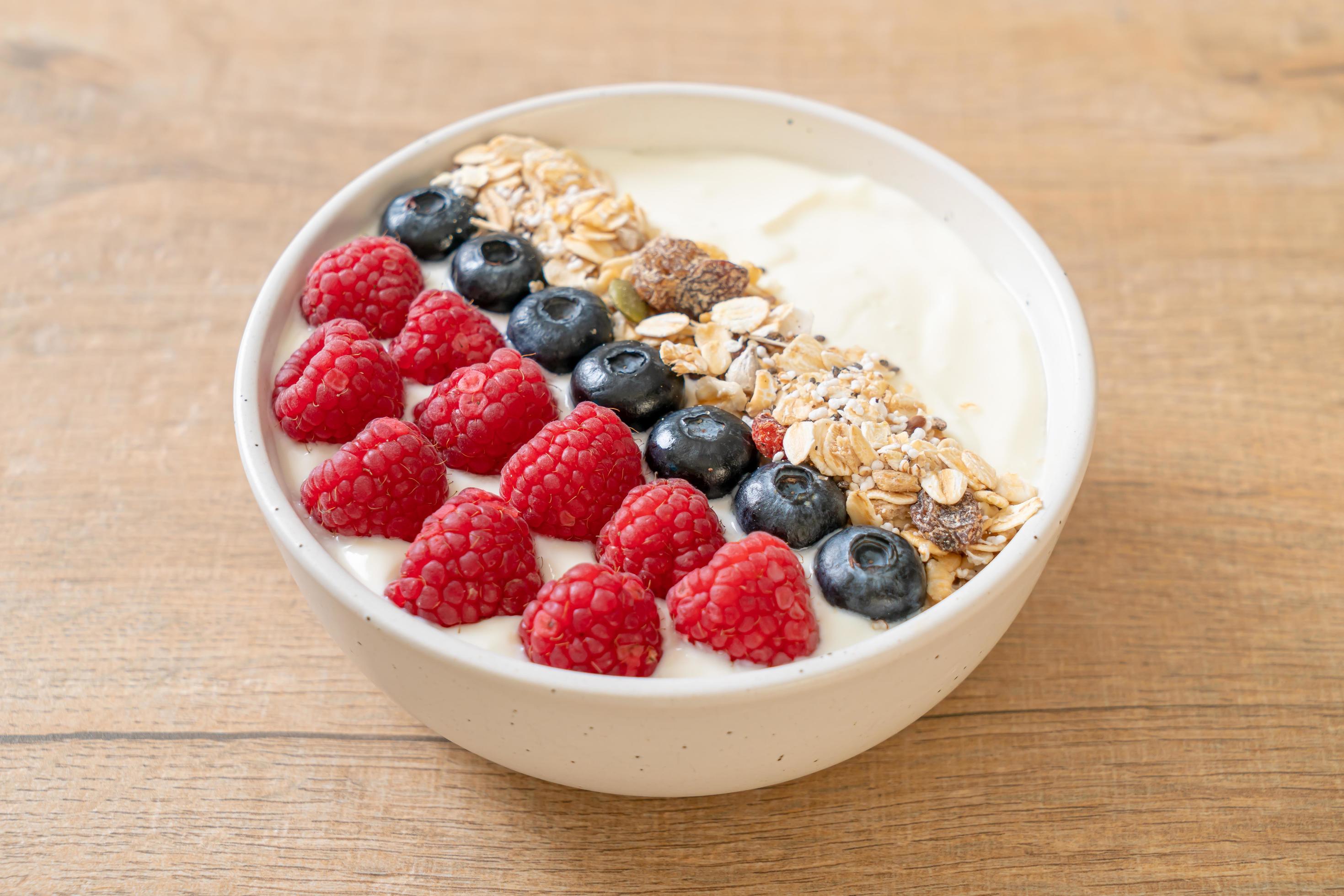 Homemade yogurt bowl with raspberry, blueberry, and granola – healthy food style Stock Free