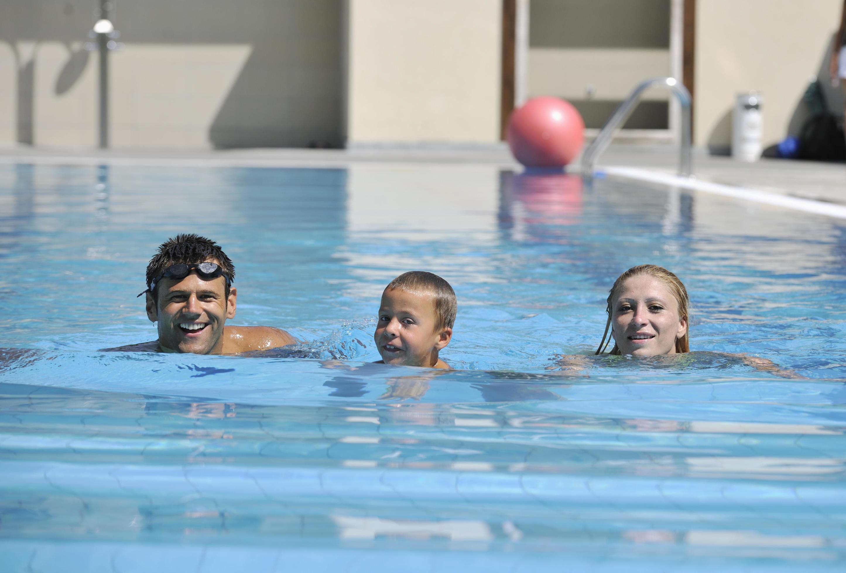 happy young family have fun on swimming pool Stock Free