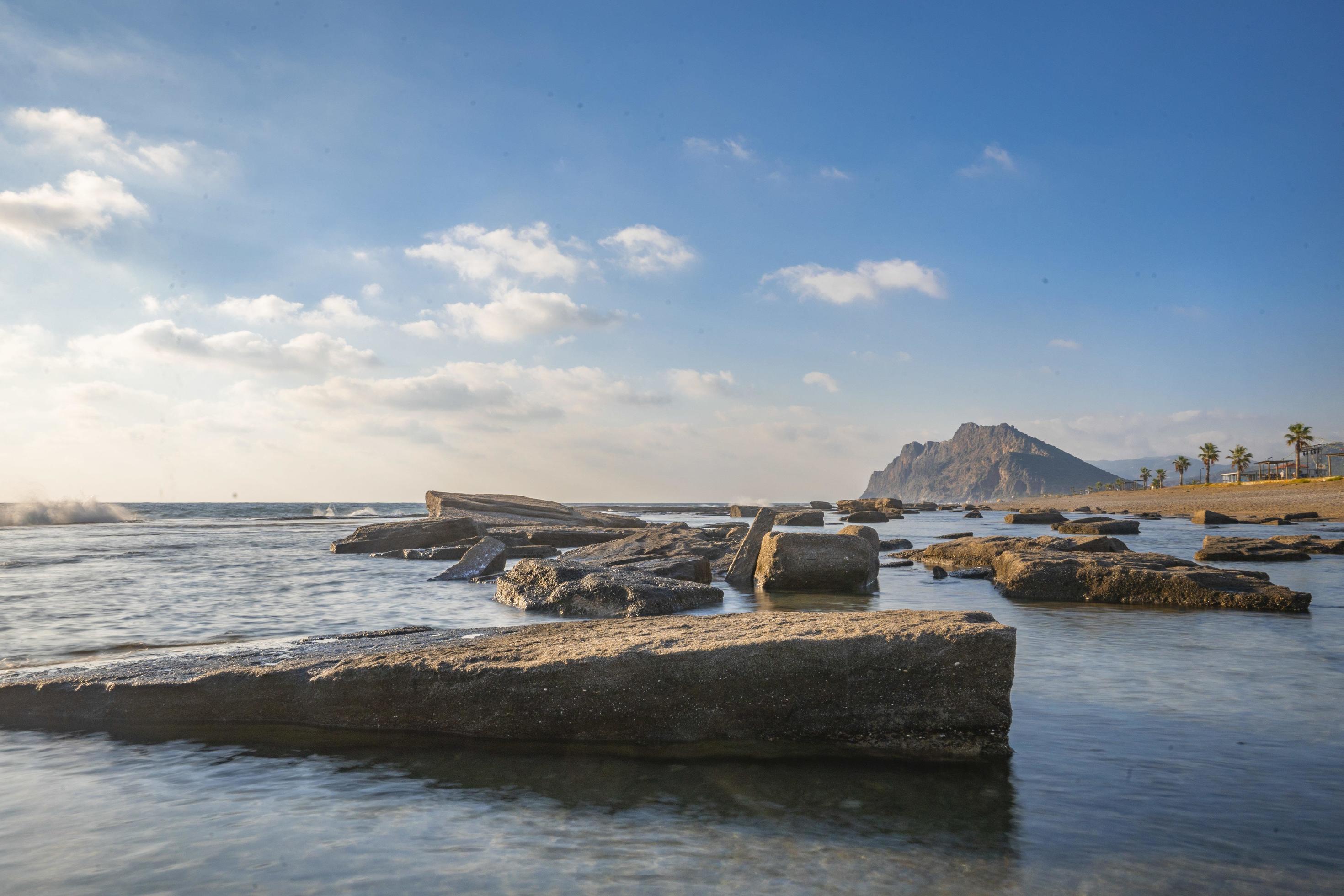 Long exposure photography of waves and pebbles on Beach in the sunset Stock Free