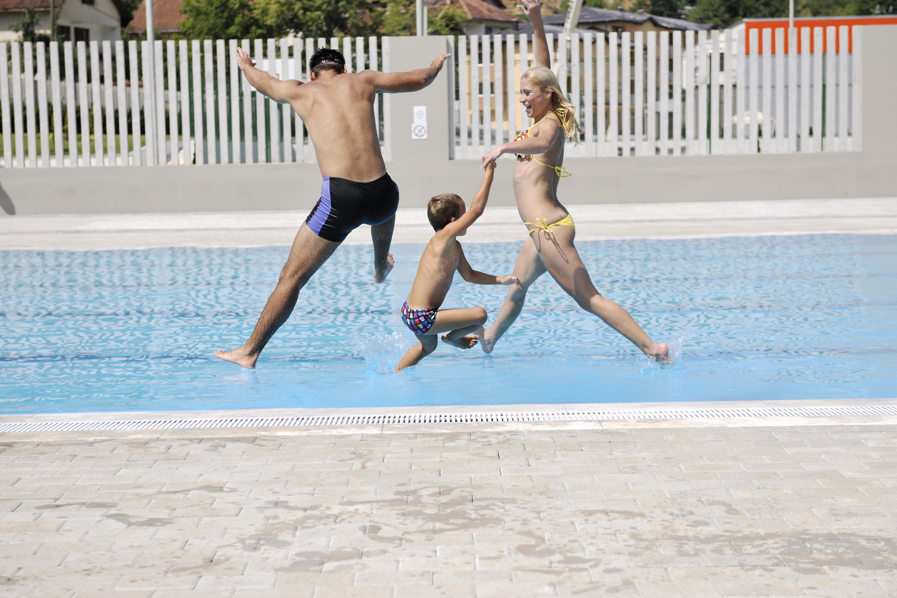 happy young family have fun on swimming pool Stock Free