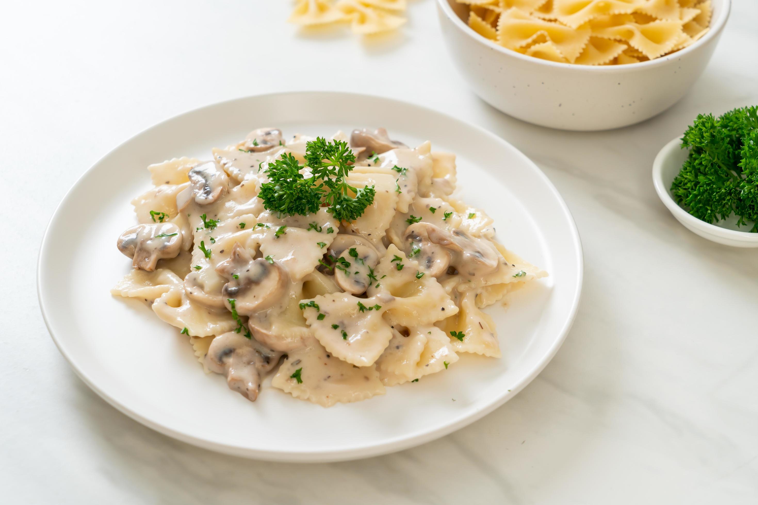 Farfalle pasta with mushroom white cream sauce – Italian food style Stock Free