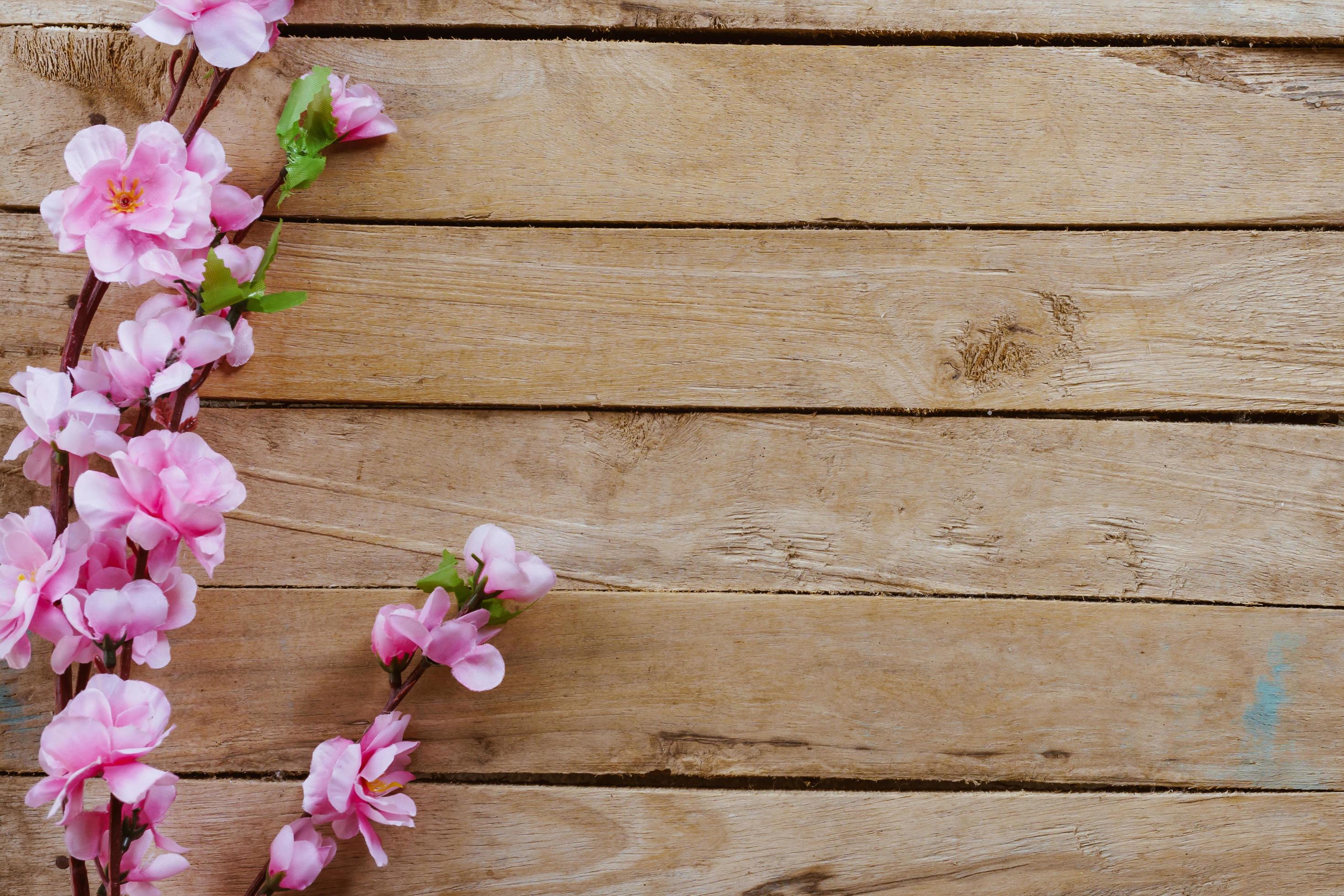 Cherry blossom and Artificial flowers on vintage wooden background with copy space. Stock Free