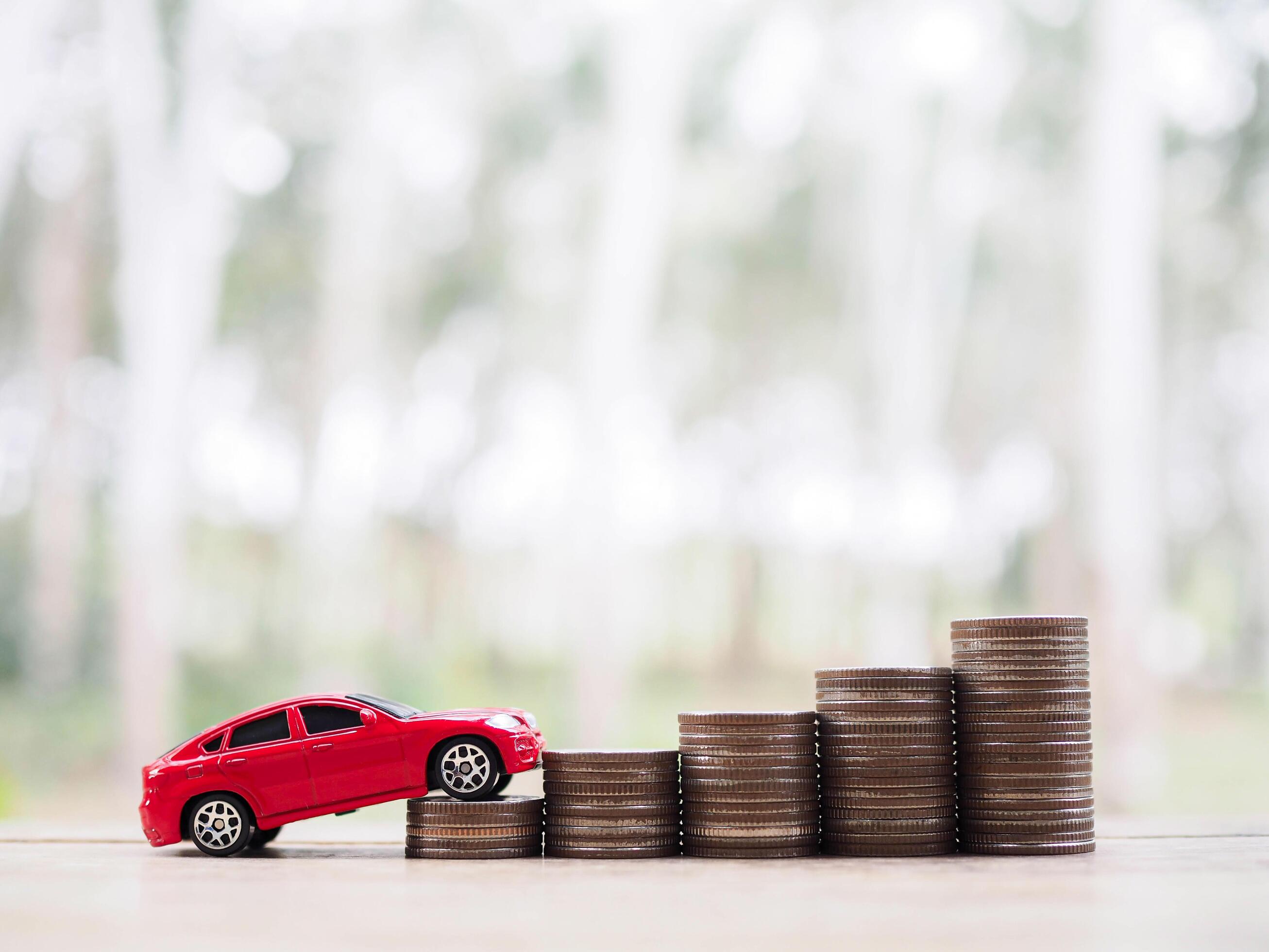 Toy cars on stack of coins. The concept of saving money and manage to success transport business Stock Free