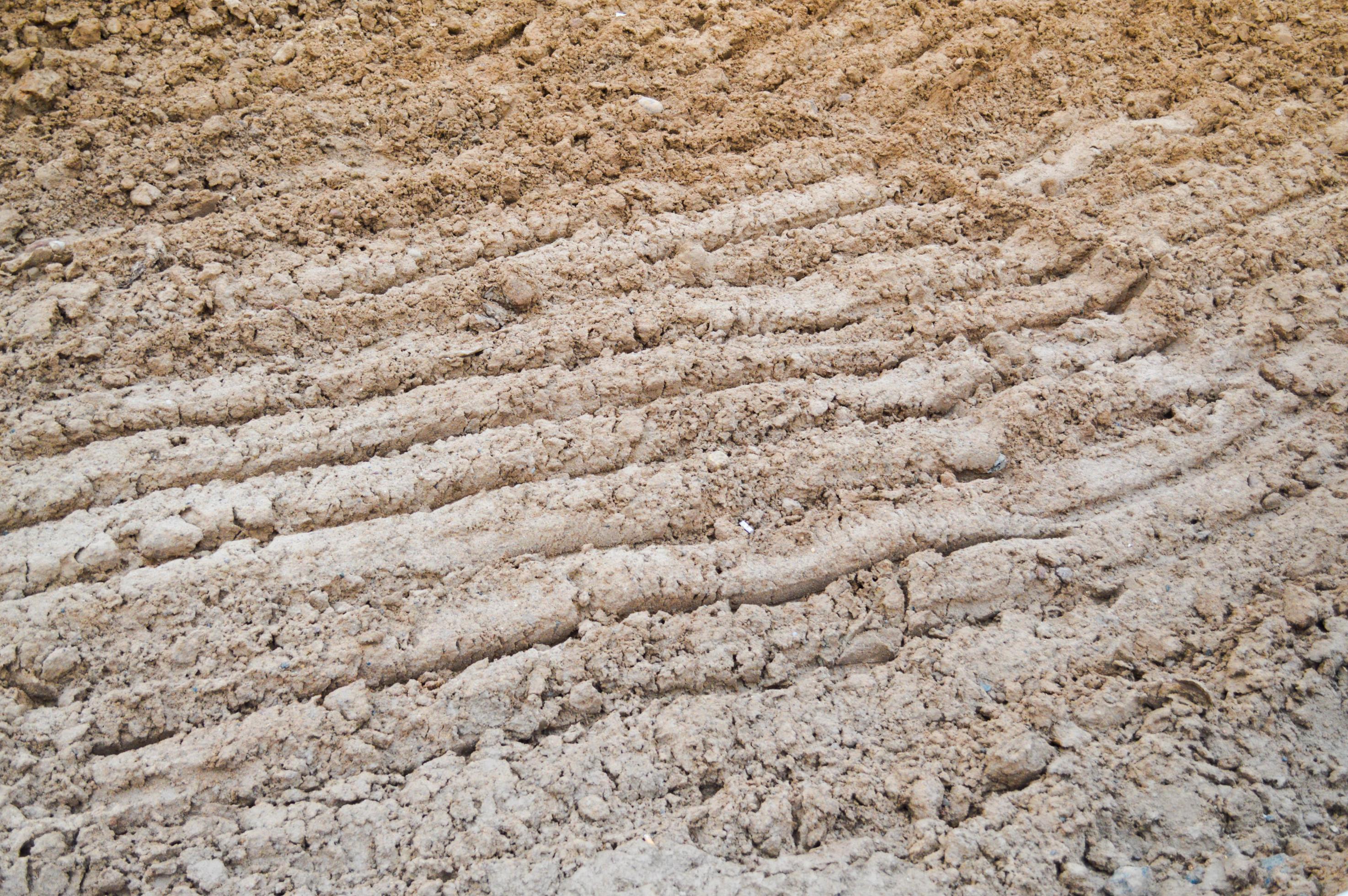 View of brown cracked natural moist earth clay. The background. Texture Stock Free