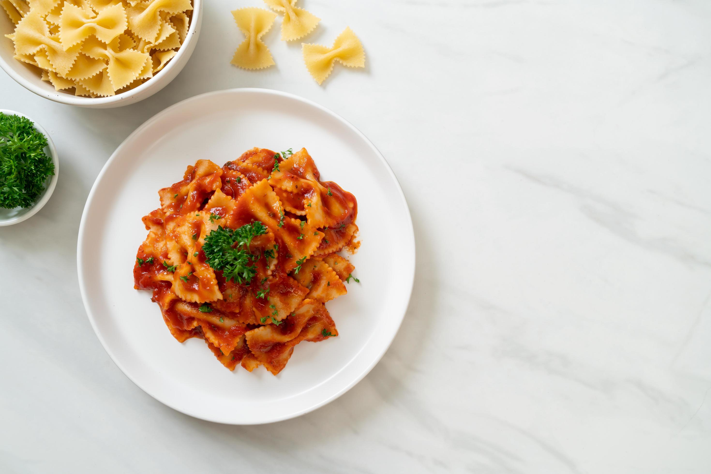 Farfalle pasta in tomato sauce with parsley – Italian food style Stock Free