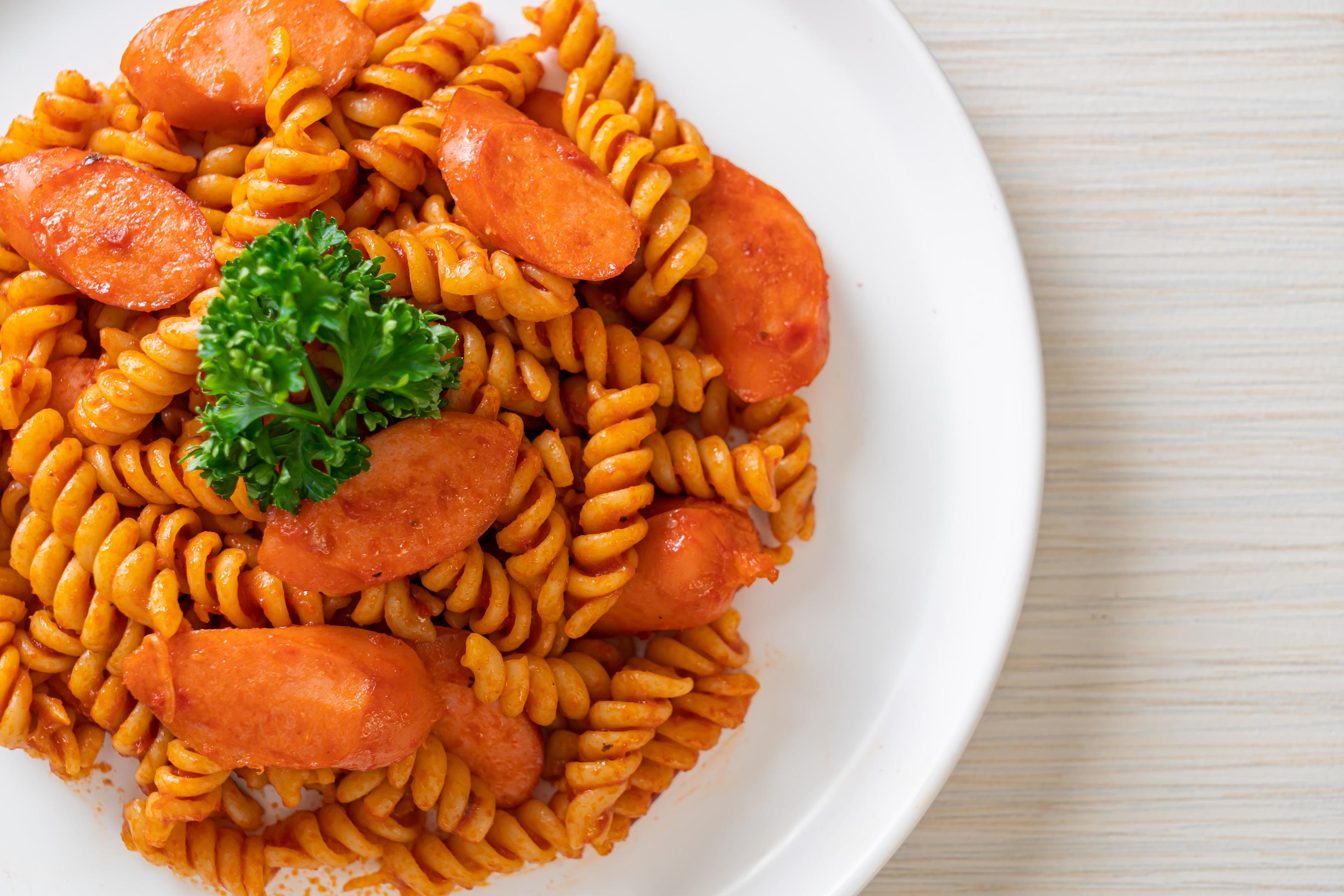 Spiral or spirali pasta with tomato sauce and sausage – Italian food style Stock Free