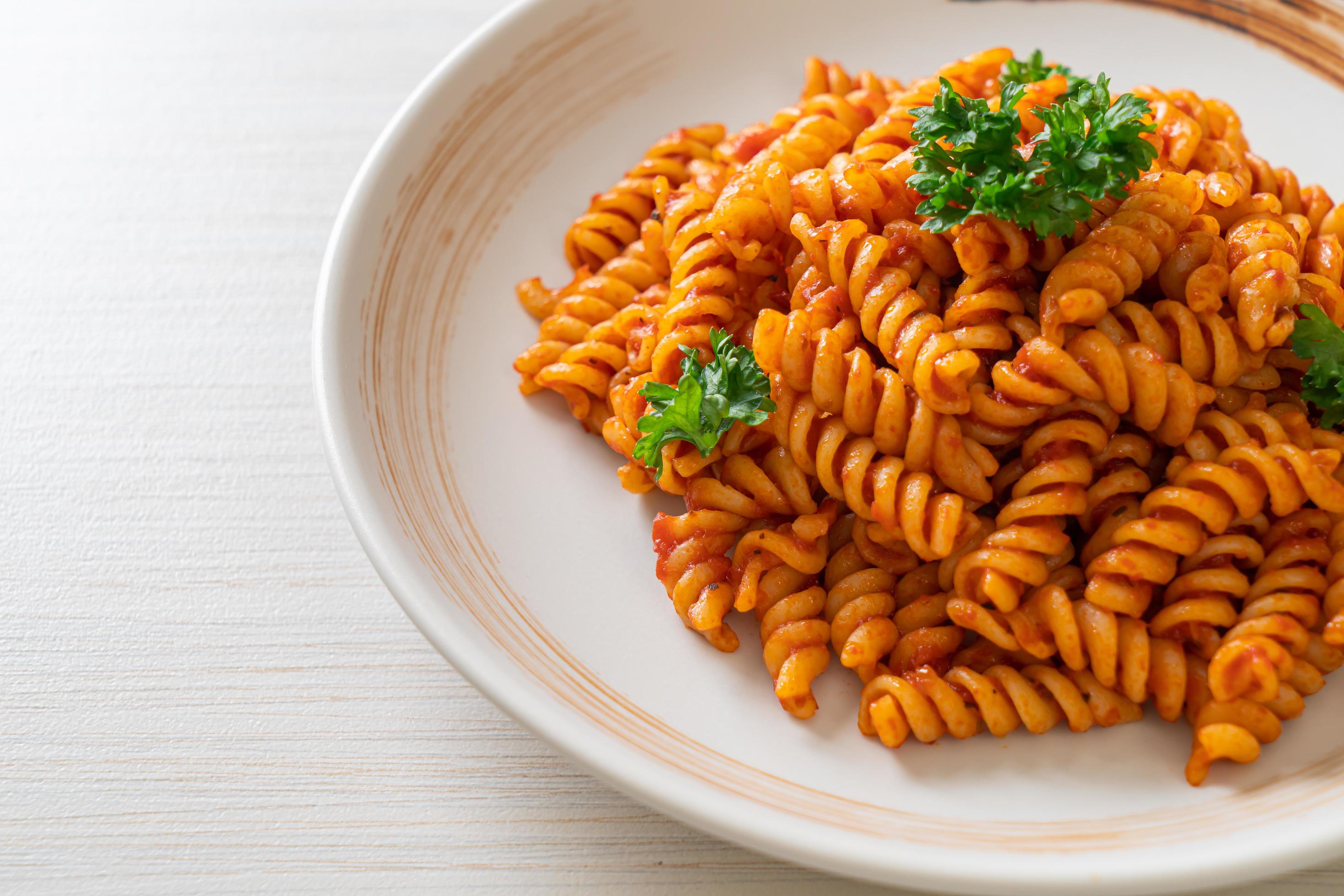 Spiral or spirali pasta with tomato sauce and sausage – Italian food style Stock Free