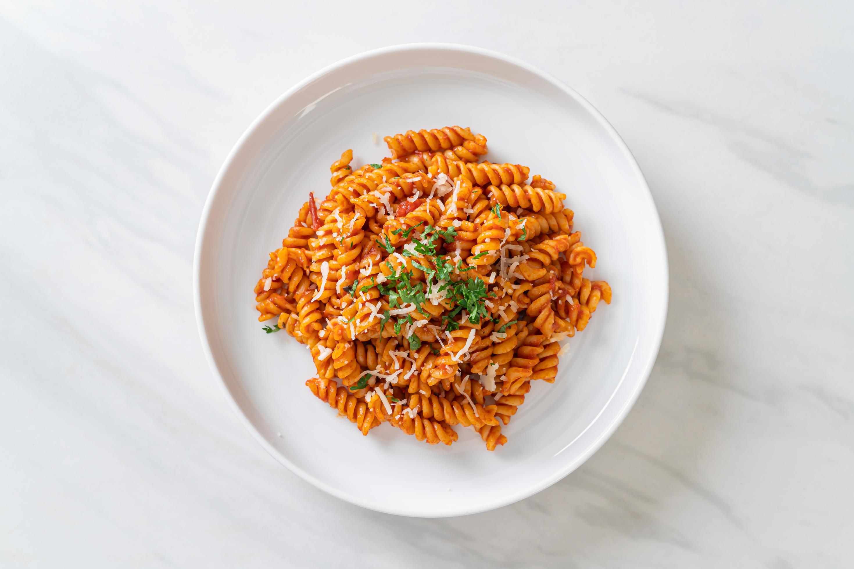 Spiral or spirali pasta with tomato sauce and sausage – Italian food style Stock Free