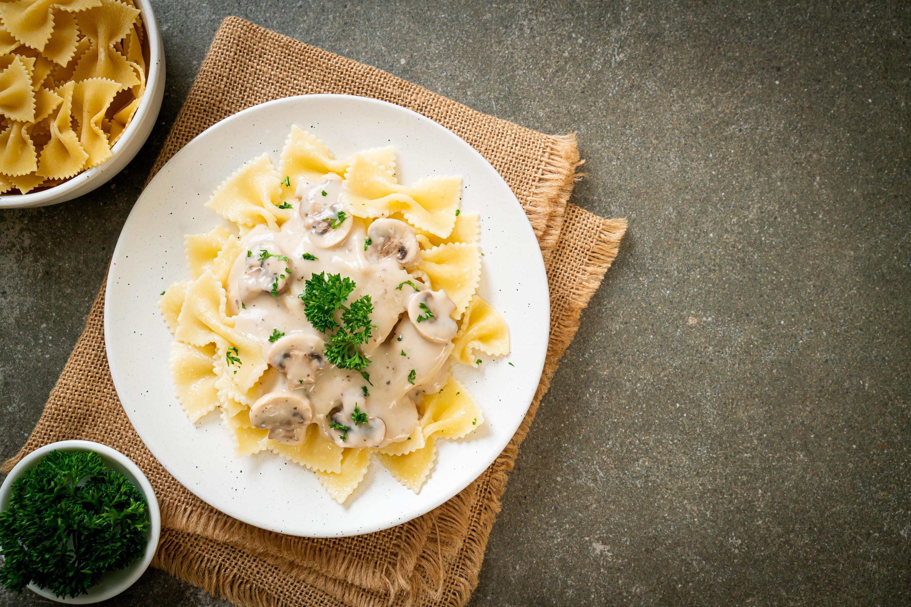 Farfalle pasta with mushroom white cream sauce – Italian food style Stock Free