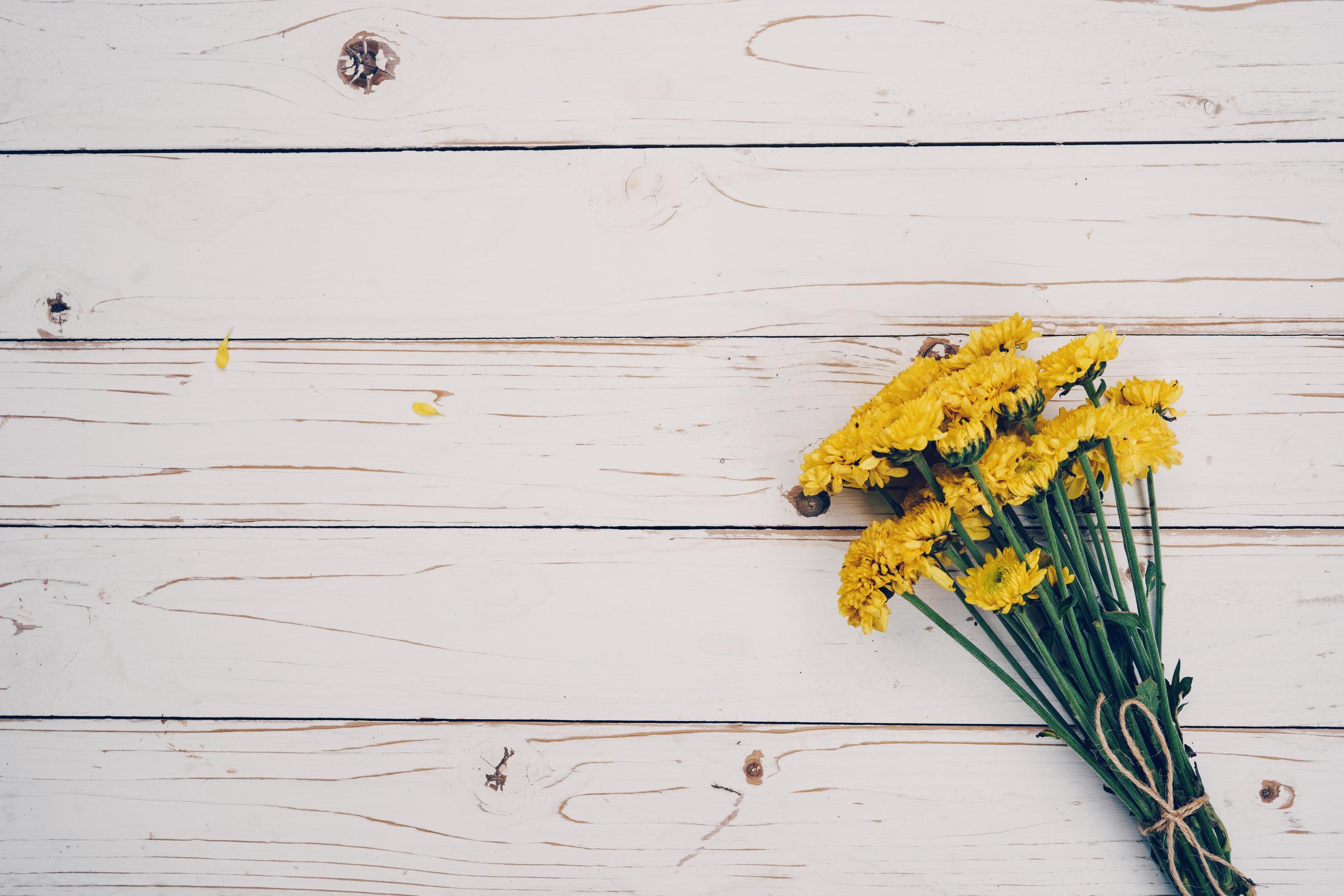 Yellow flowers of bouquet, top view on white wooden background texture with copy space Stock Free