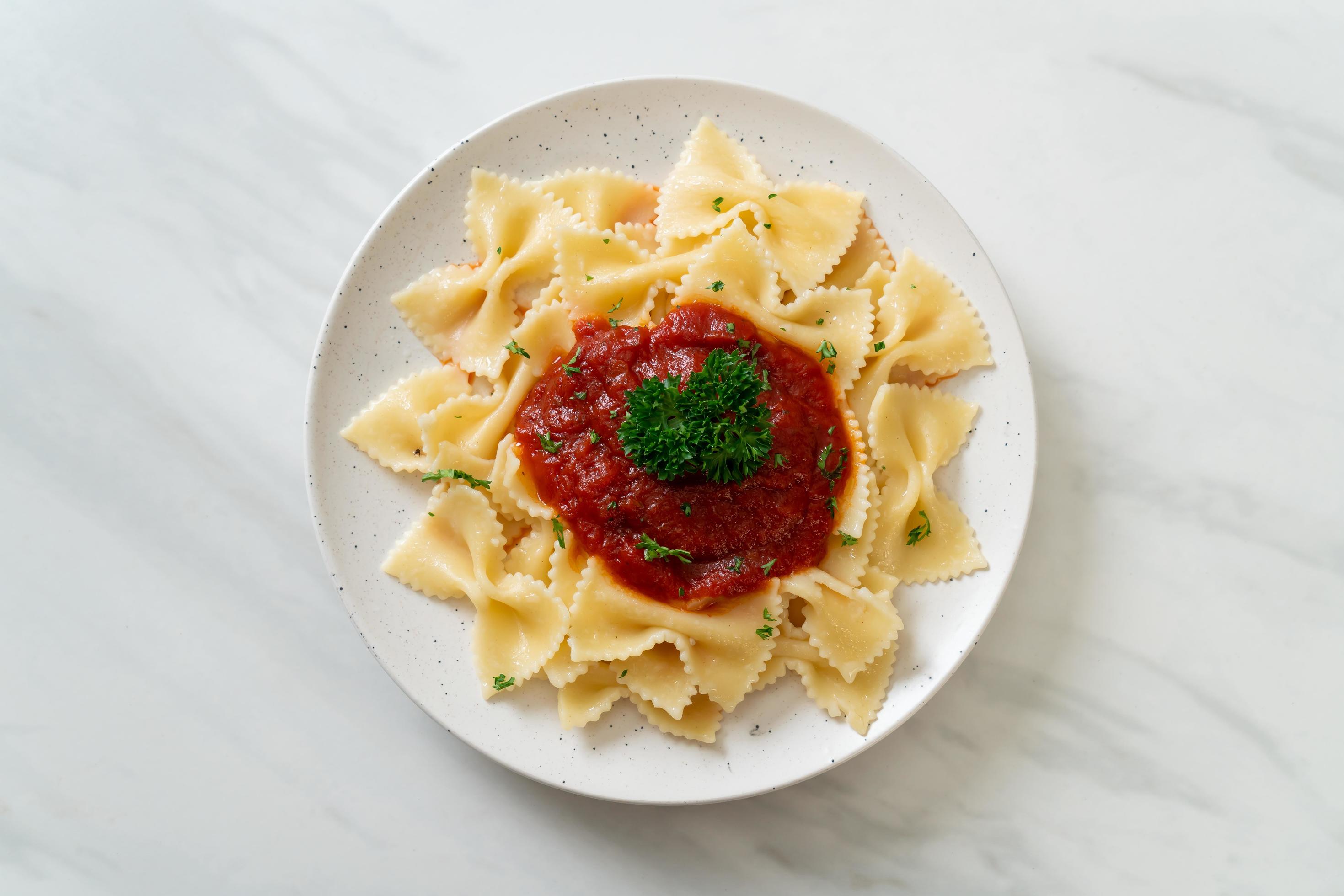 Farfalle pasta in tomato sauce with parsley – Italian food style Stock Free