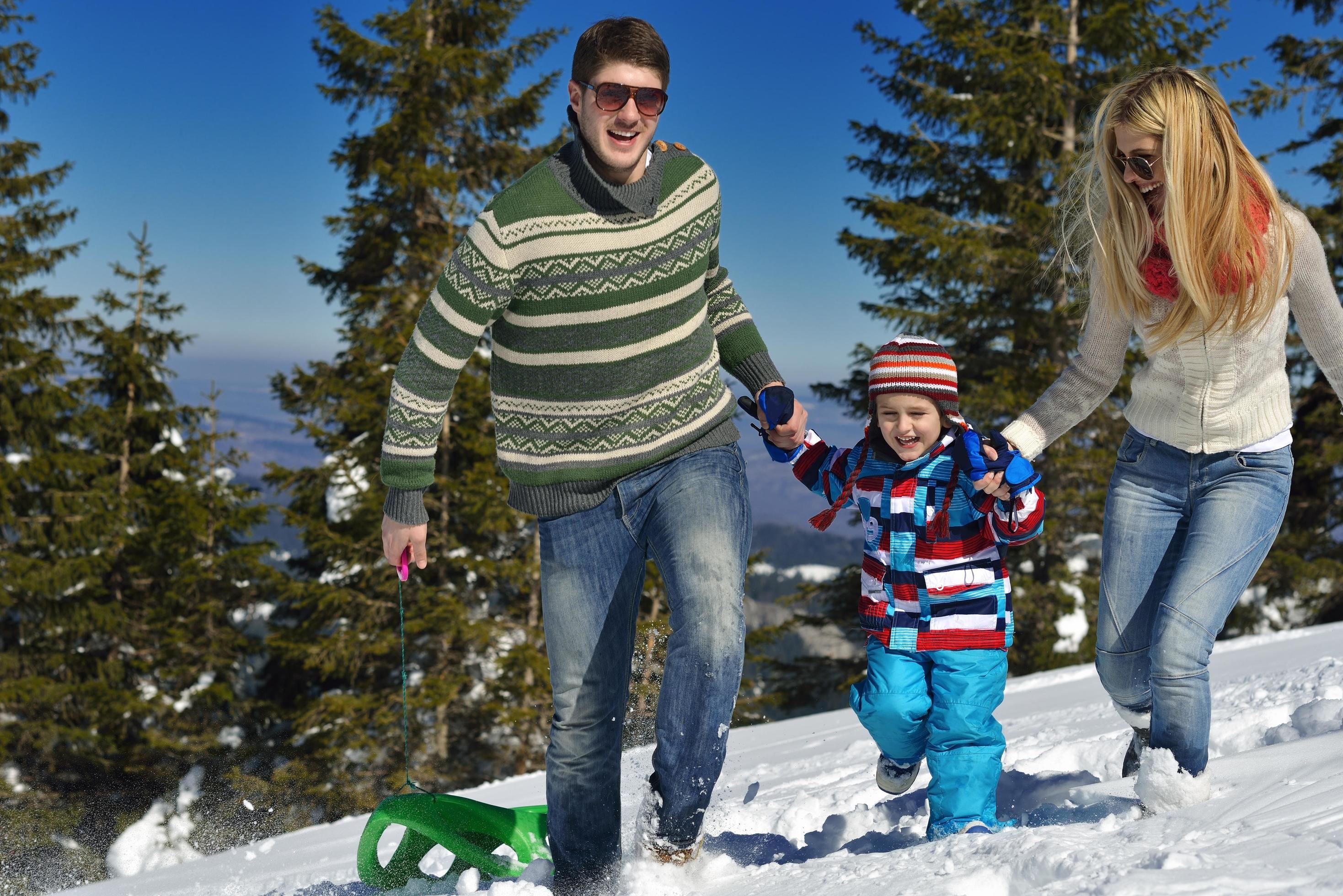 family having fun on fresh snow at winter vacation Stock Free