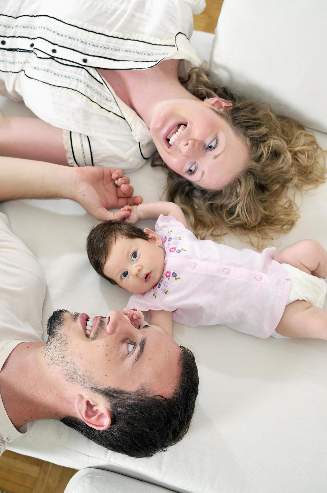 indoor portrait with happy young family and cute little babby Stock Free