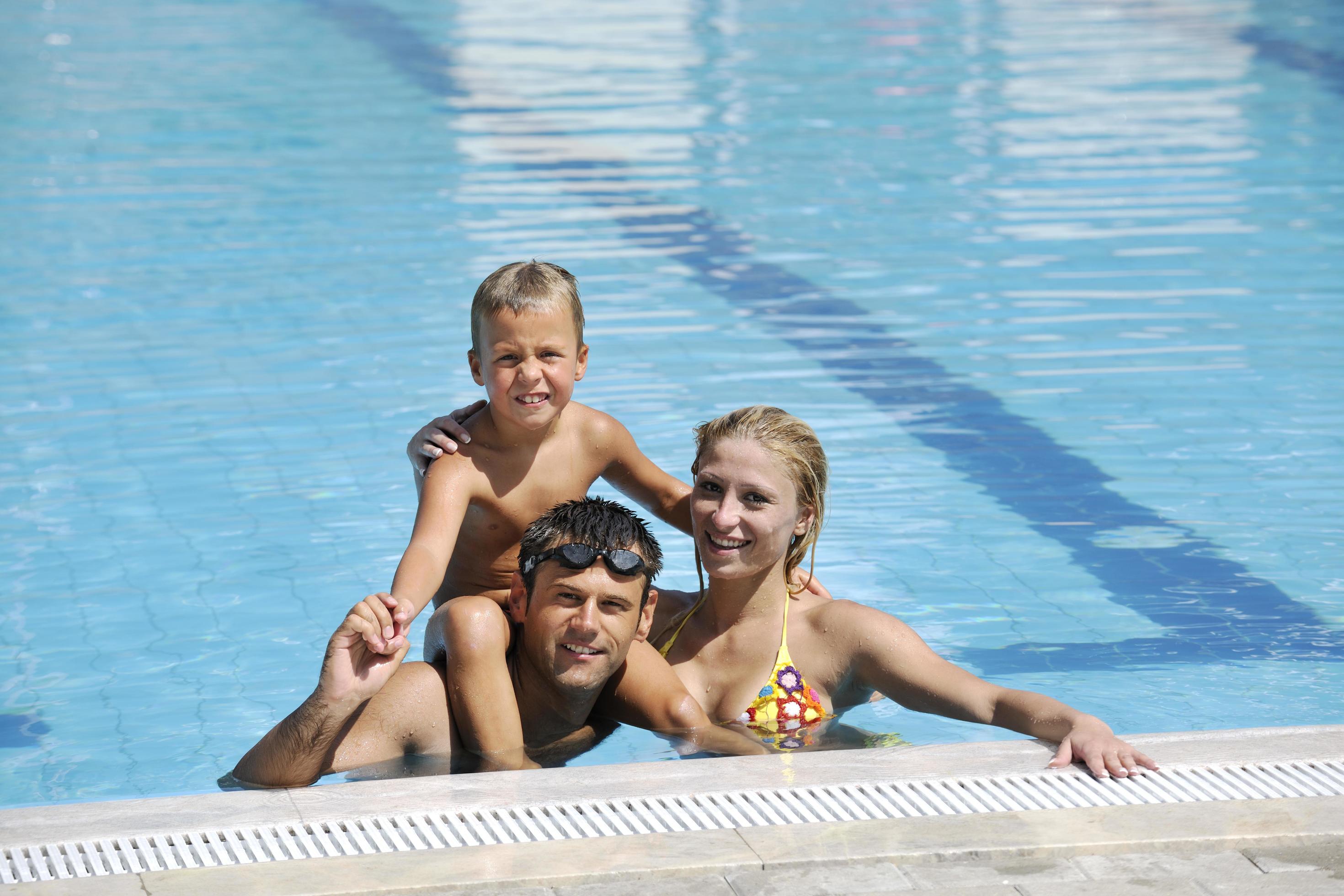 happy young family have fun on swimming pool Stock Free