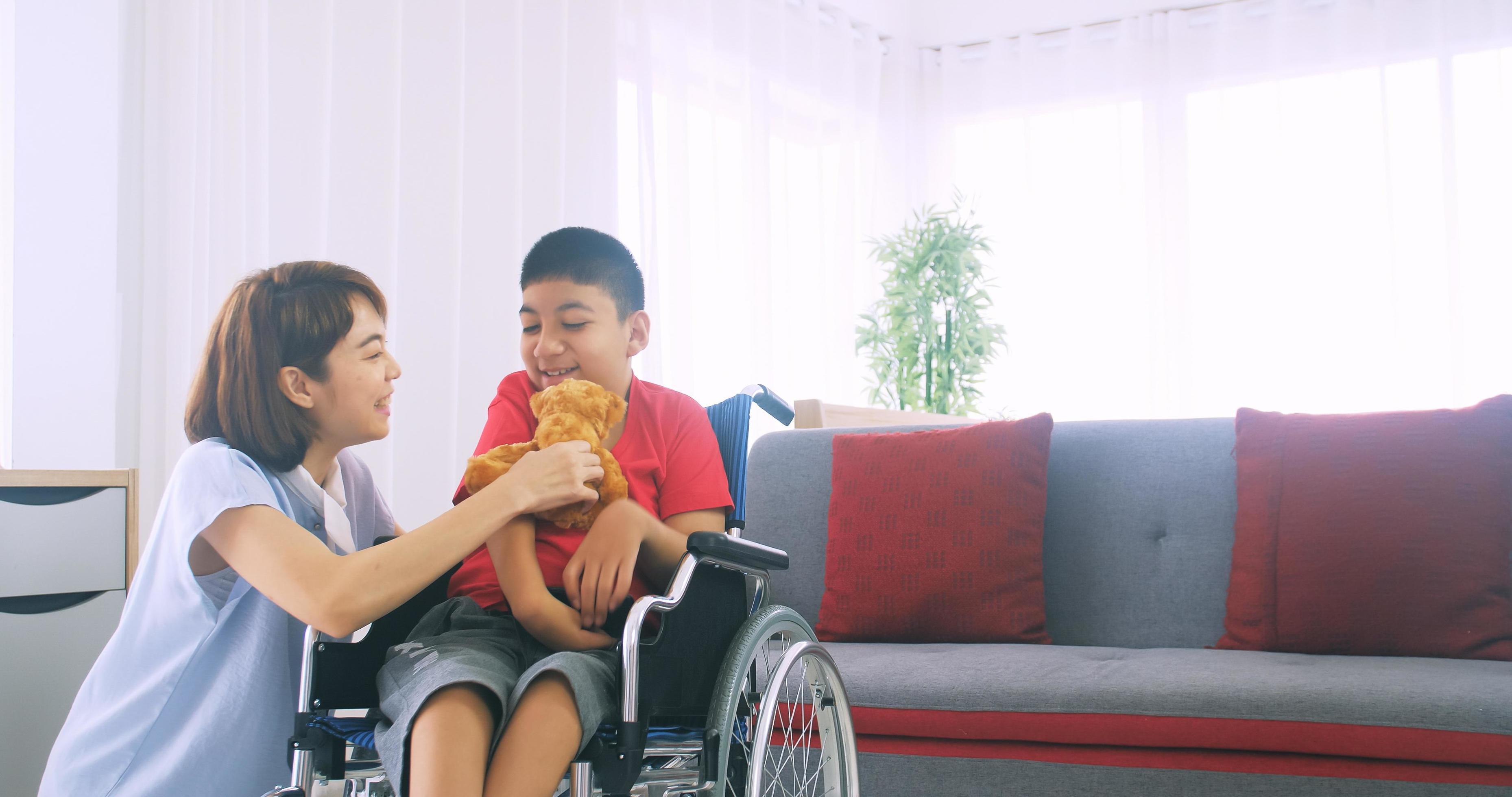 Happy family with mother and disabled son spending time together at home. Stock Free