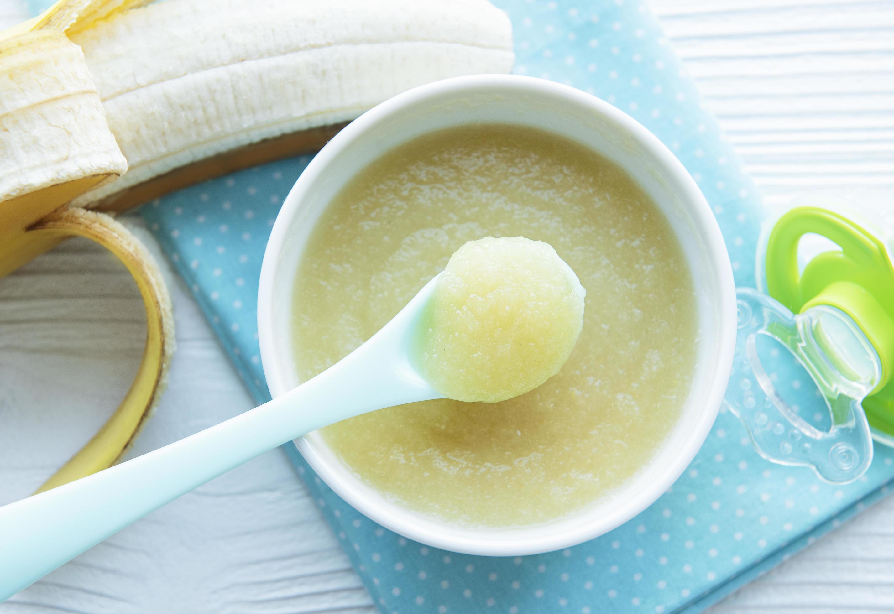 Bowl with fruit baby food and banana Stock Free