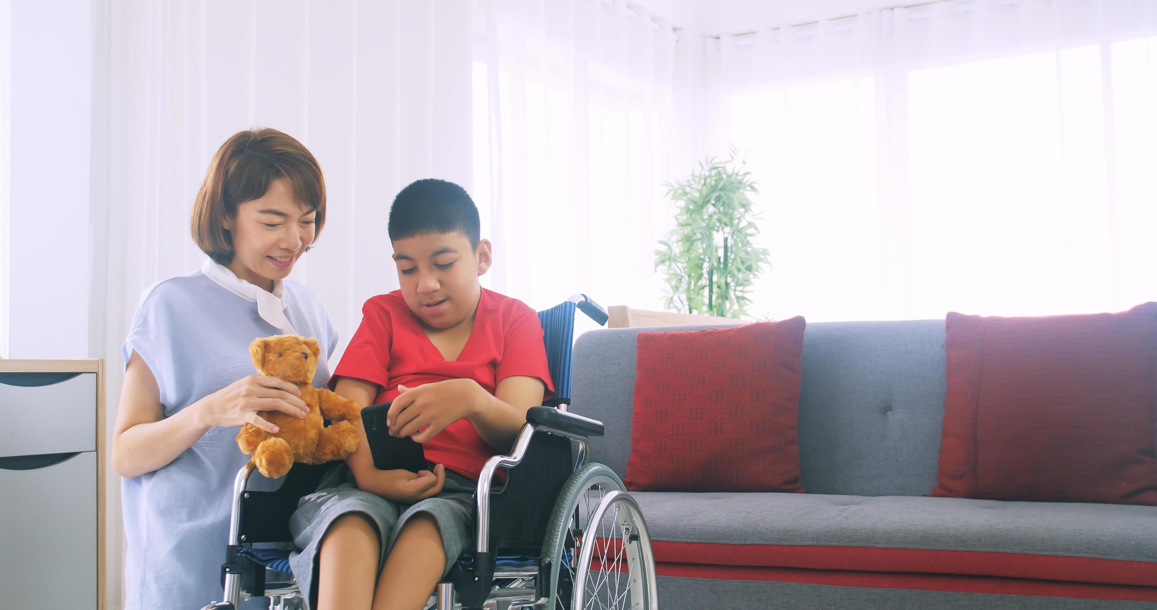 Happy family with mother and disabled son spending time together at home. Stock Free