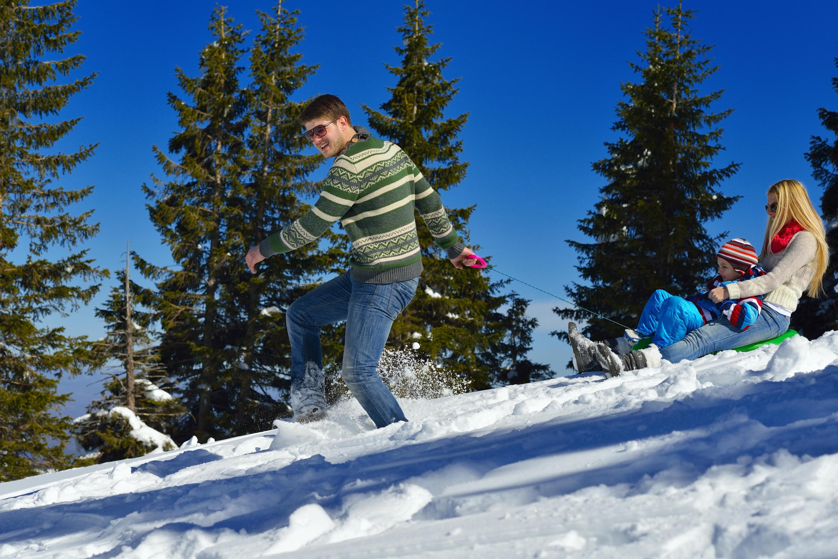 family having fun on fresh snow at winter vacation Stock Free