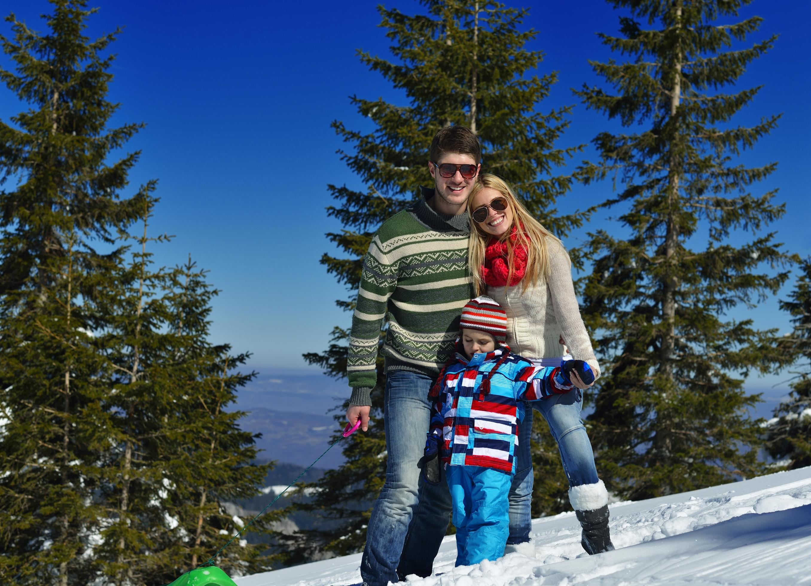 family having fun on fresh snow at winter vacation Stock Free