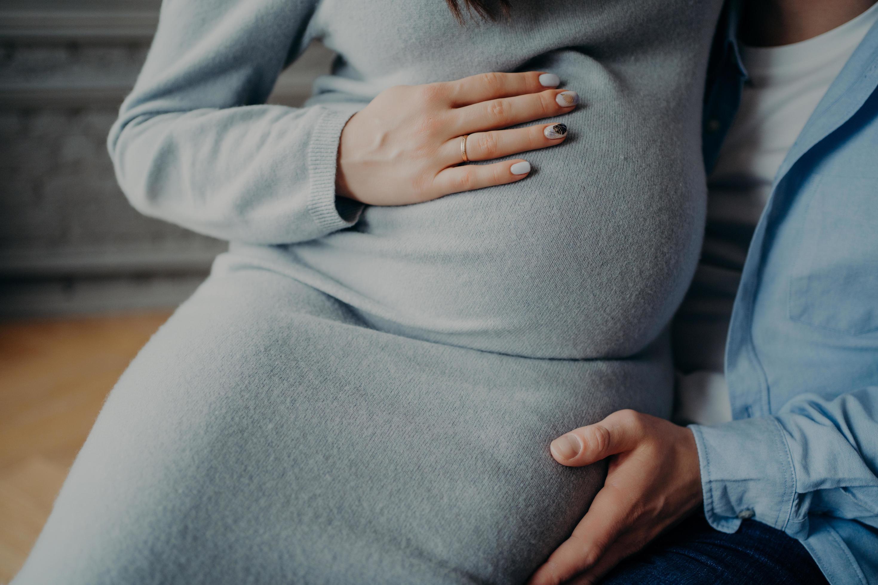 Pregnant woman and her husband await for baby going to become happy parents. Pregnancy love family relationship concept. Cropped image Stock Free