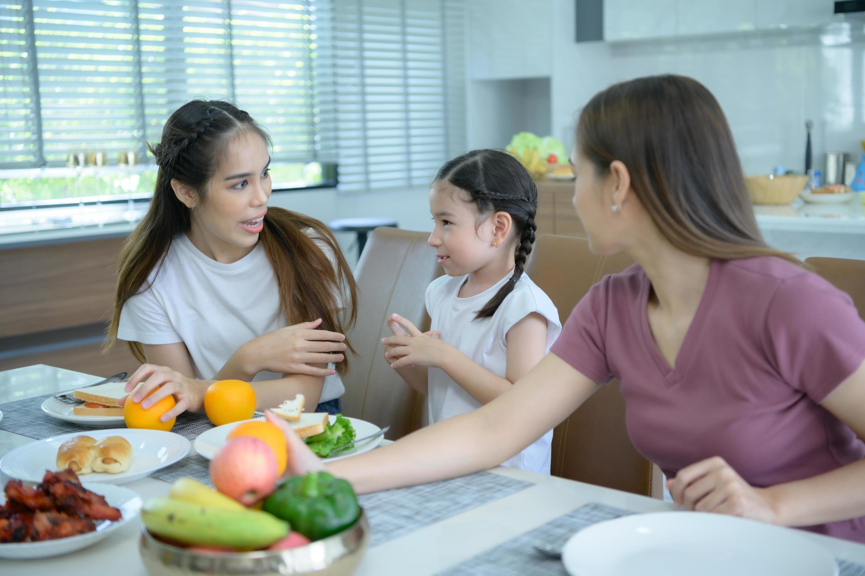 Asian family They are having breakfast together happily in the dining room of the house. Stock Free