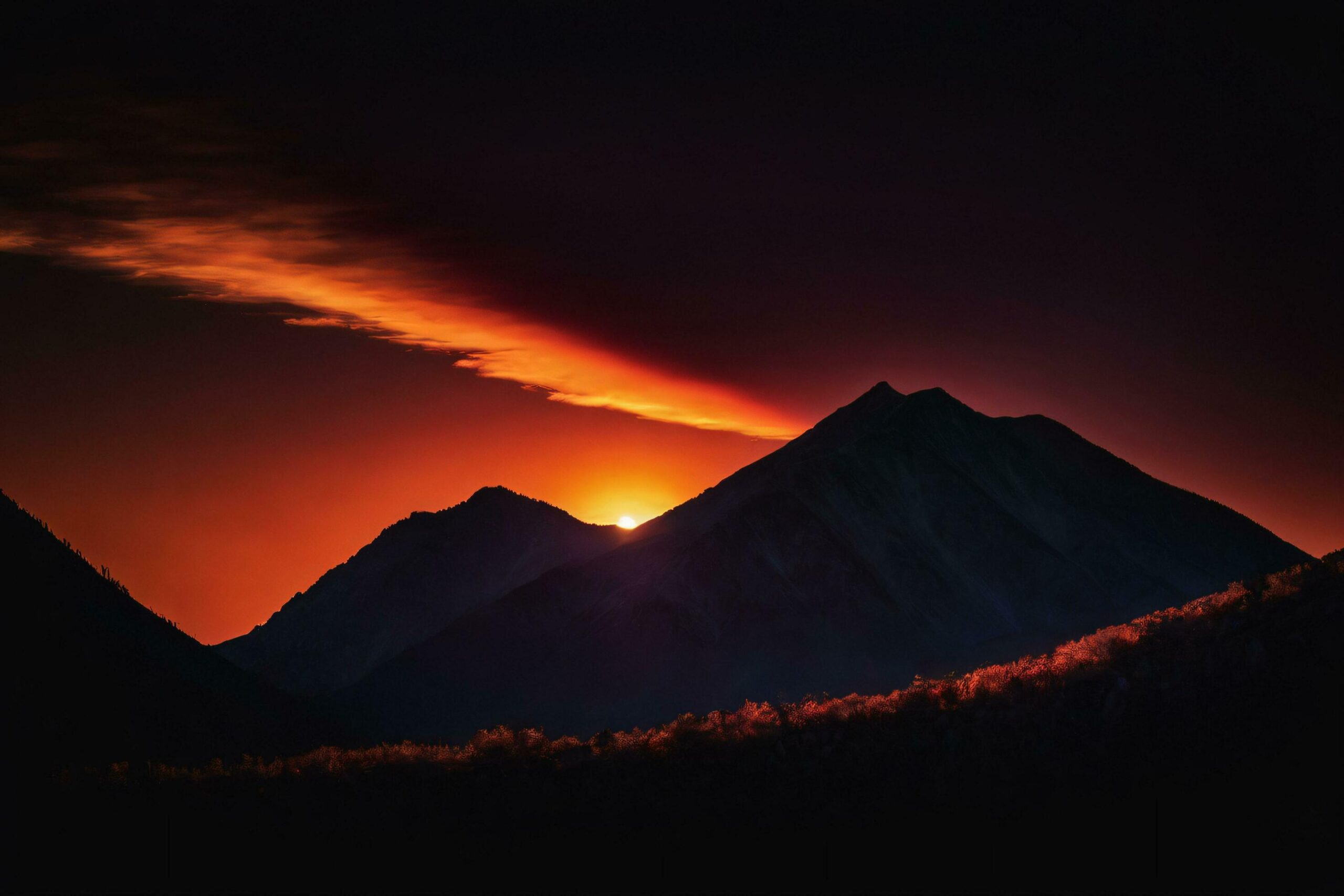 Mountain Peaks Silhouetted Against Fiery Sunset Free Photo