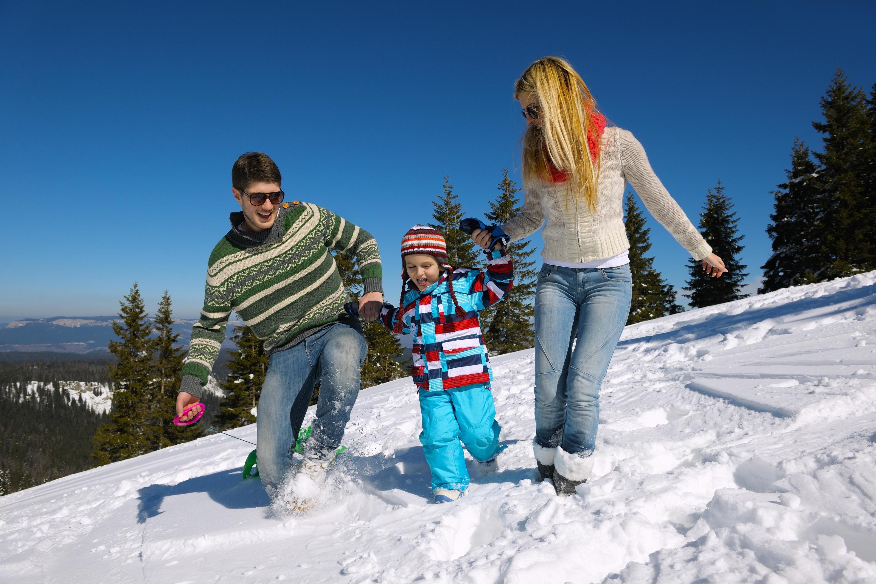 family having fun on fresh snow at winter vacation Stock Free