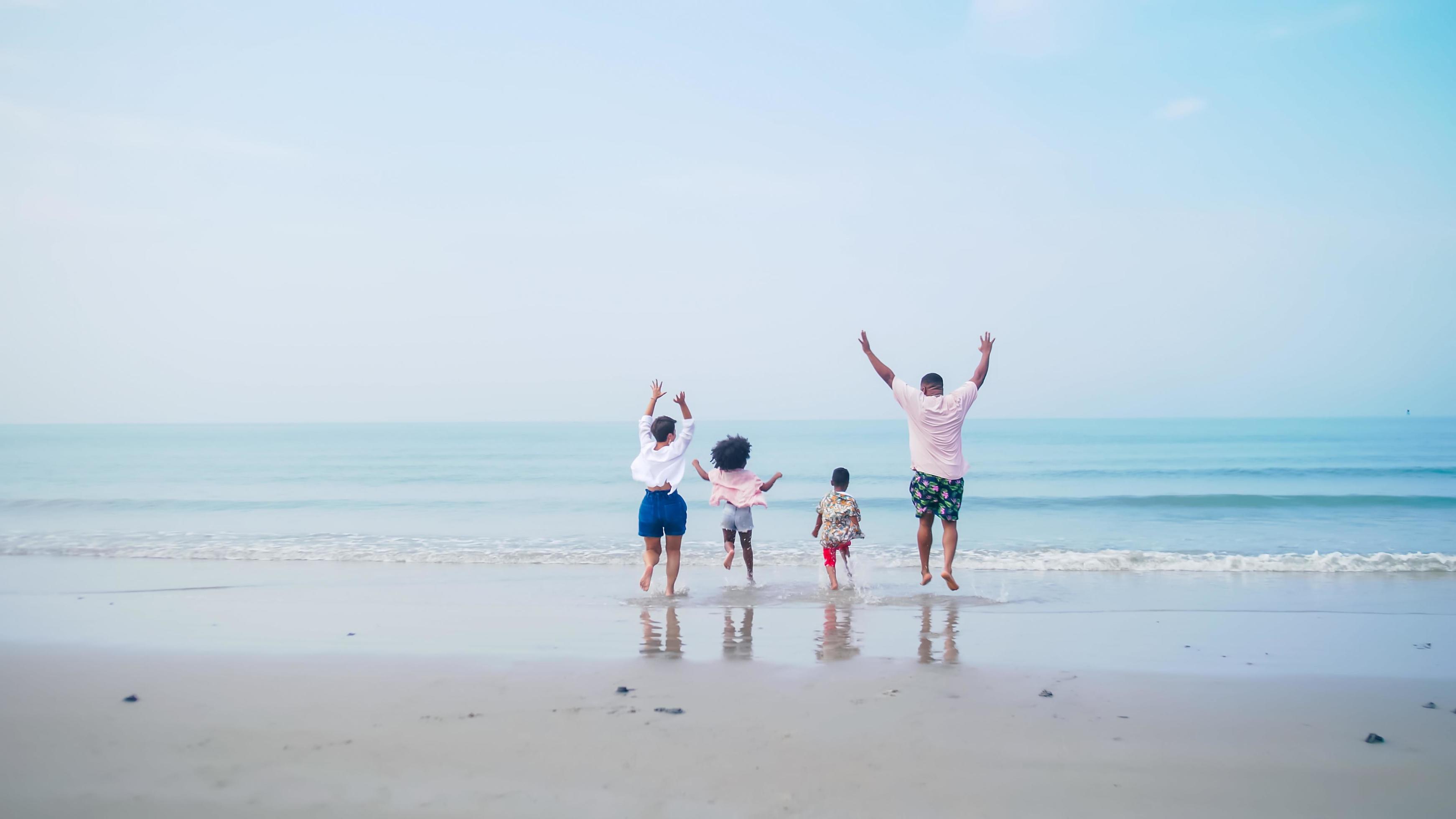 Family having fun playing together on the beach. Stock Free