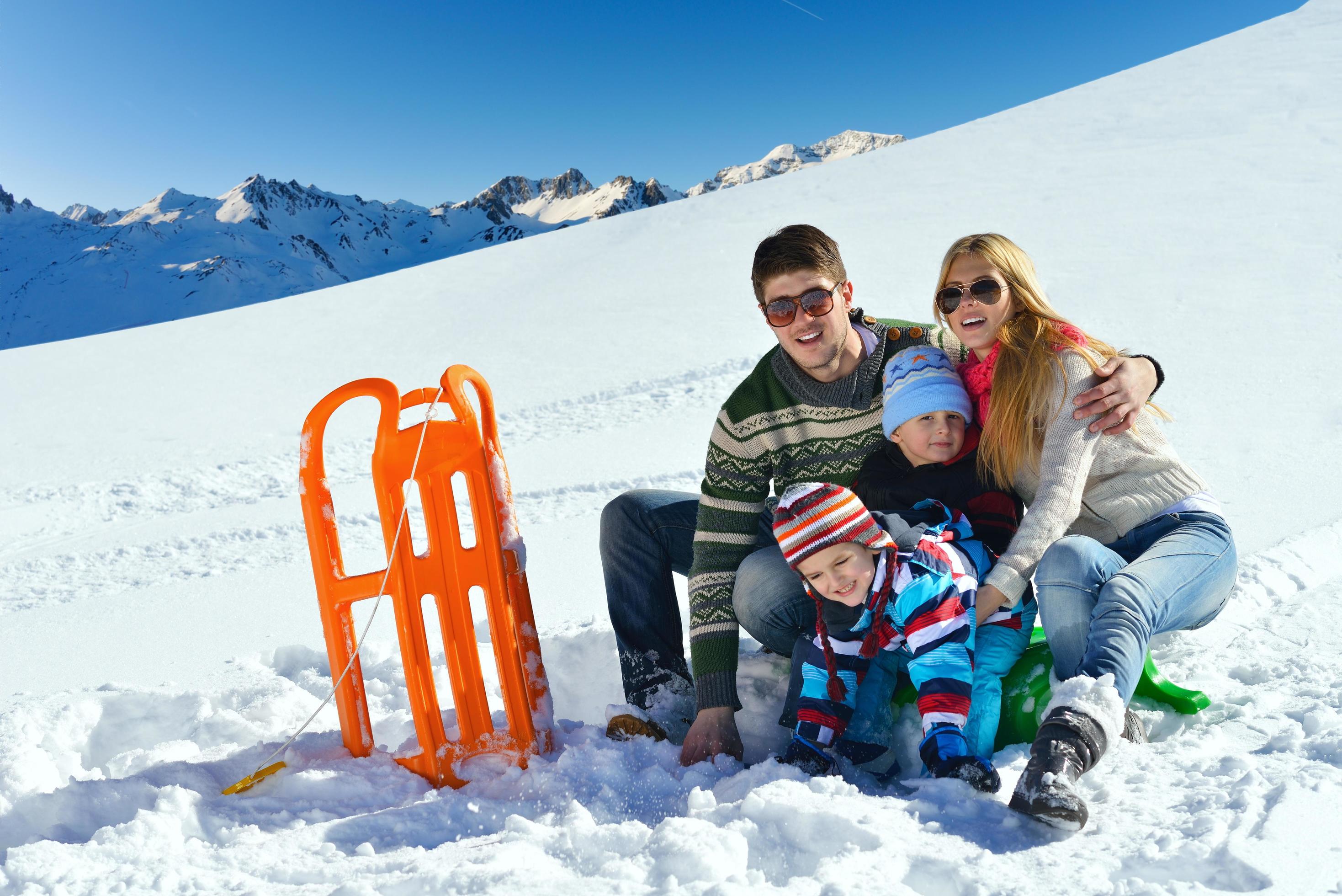 family having fun on fresh snow at winter vacation Stock Free